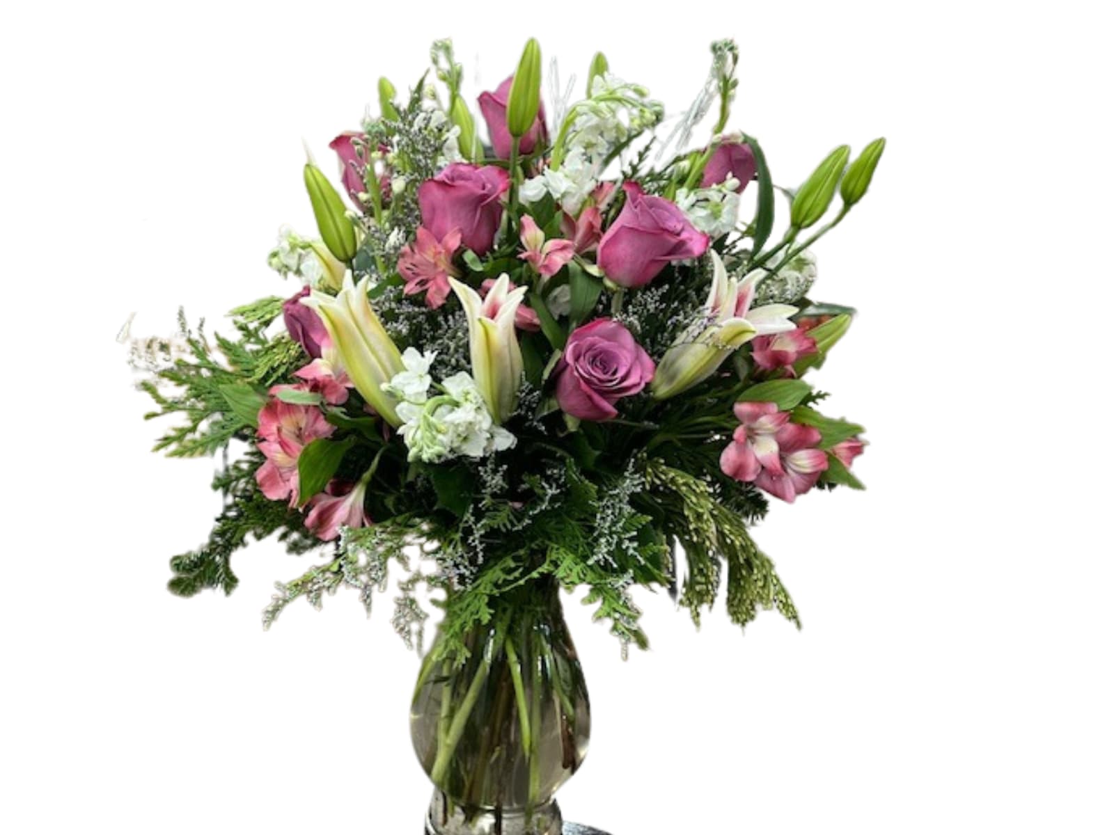 Warm & Cozy Warm & Cozy - Arrangement featuring Lilies and long stem lavender roses designed in tall clear glass vase