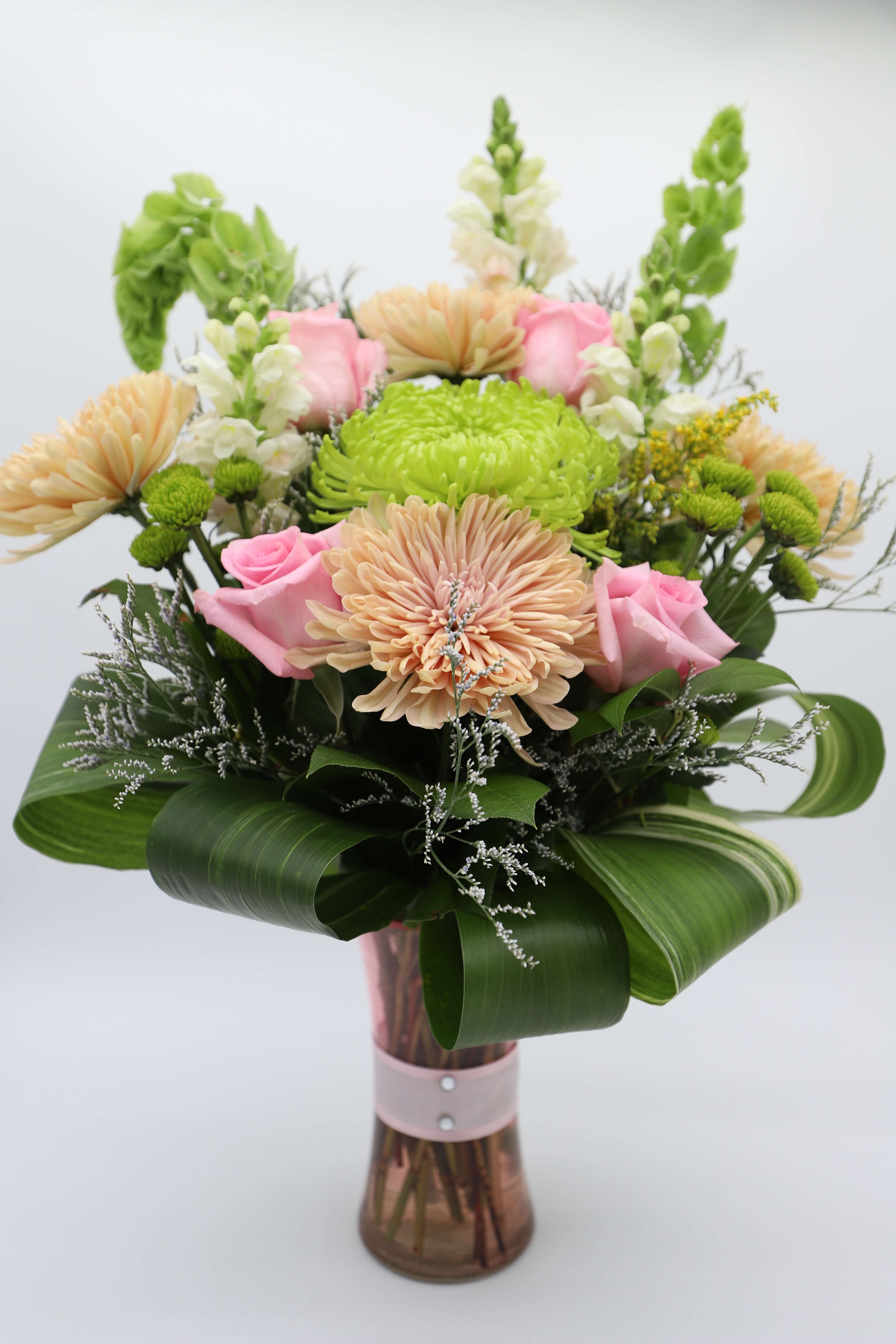 Appreciate Mum - A gorgeous arrangement made with chrysanthemums, roses, button mums, snapdragons, bells of ireland and other filler/greenery - designed in a pink vase adorned with &quot;diamond&quot; detailing.