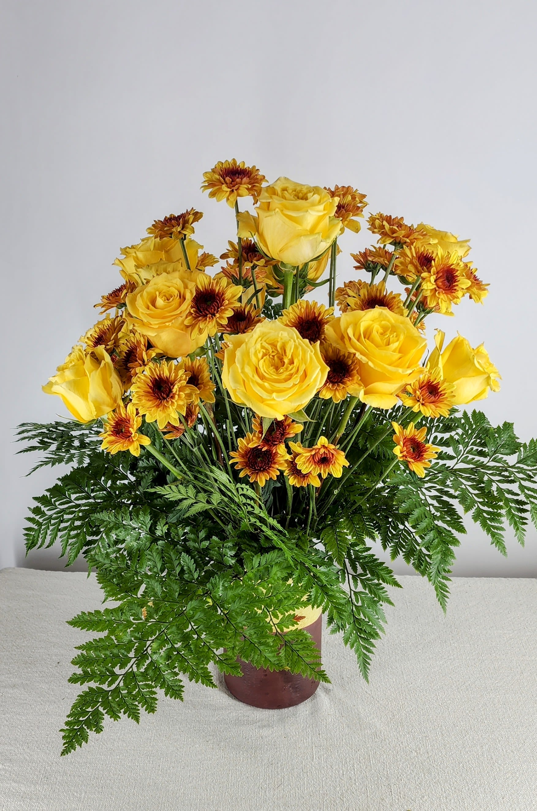A Dozen Premium Yellow Roses and Chrysanthemums - A stunning arrangement designed with twelve Premium, long stemmed roses surrounded with chrysanthemums and nestled in a nest of greens.