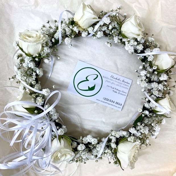 Floral Crown / Halo with Tiny Roses - Elevate your special moments with our Floral Crown or Halo with Tiny Roses, a breathtaking headpiece that exudes timeless beauty and effortless grace. Crafted with a ring of fresh natural foliage, delicate baby’s breath, and the charming addition of tiny roses, this crown is the perfect accessory for confirmations, serving girls, proms, homecoming dances, recitals, and weddings. Its exquisite craftsmanship and sophisticated design make it a truly remarkable piece for any cherished celebration. -Key Features: **Fresh Natural Foliage: A lush, organic base that sets the tone for a natural and elegant look. **Delicate Baby’s Breath: Soft, cloud-like blooms add a touch of romance and ethereal beauty. **Charming Tiny Roses: Petite roses bring a pop of color and sophistication, elevating the crown’s overall design. **Lightweight and Comfortable: Designed for all-day wear without sacrificing comfort or style. **Versatile Design: Complements a variety of hairstyles and outfits, making it suitable for both formal and semi-formal events. NOTE: 18 to 22 inches in circumferences. LET US KNOW YOUR SIZE.  White or cream color roses unless you specify differently. Whether you’re celebrating a wedding, recital, or special milestone, this floral crown with tiny roses is a stunning addition to your look. Order yours today and let its charm and elegance make your celebration unforgettable!