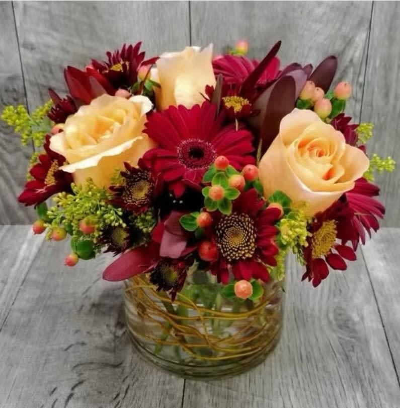 Rustic Radiance - Immerse yourself in elegance with our Rustic Radiance Bouquet. Featuring rich maroon gerberas and creamy roses, this arrangement is beautifully complemented by delicate greens. Perfect for adding a touch of sophistication to any occasion.
