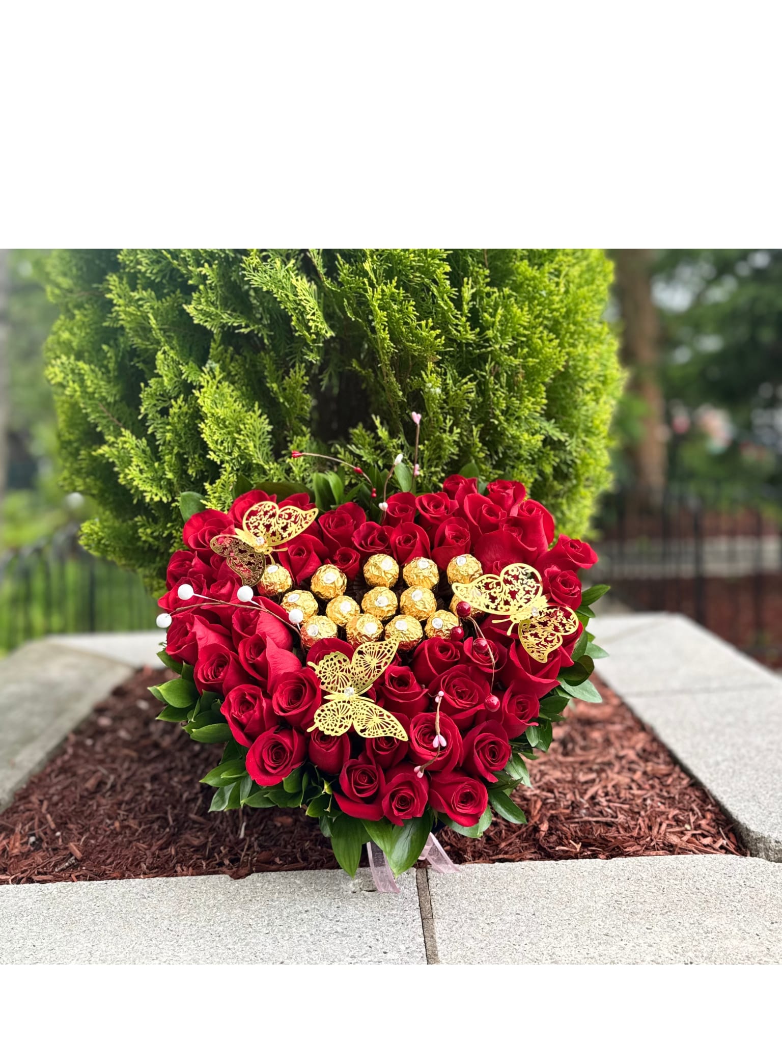 heart of roses - A stunning floral Heart made up of 50 fresh red roses, an eternal symbol of love and passion. In the centre, a golden touch of elegance with Ferrero Rocher chocolates. The design is carefully framed with natural green foliage, creating vibrant and harmonious contrasts. Perfect for special occasions such as anniversaries, proposals, Valentine's Day or simply to say 'I love you' in an unforgettable way.