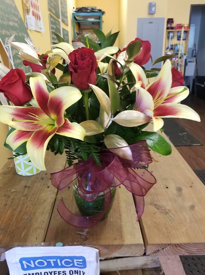 6 RED ROSES WITH 3 LILIES (DESIGNER CHOICE) - 6 RED ROSES  with 3 LILIE STEMS   NOTE: (lilies is where we sub depending on the colors of lilies we have in store)  and we used dye gold ruscus as filler.  NOTE: Deluxe price includes 9 roses Premium price includes 12 roses