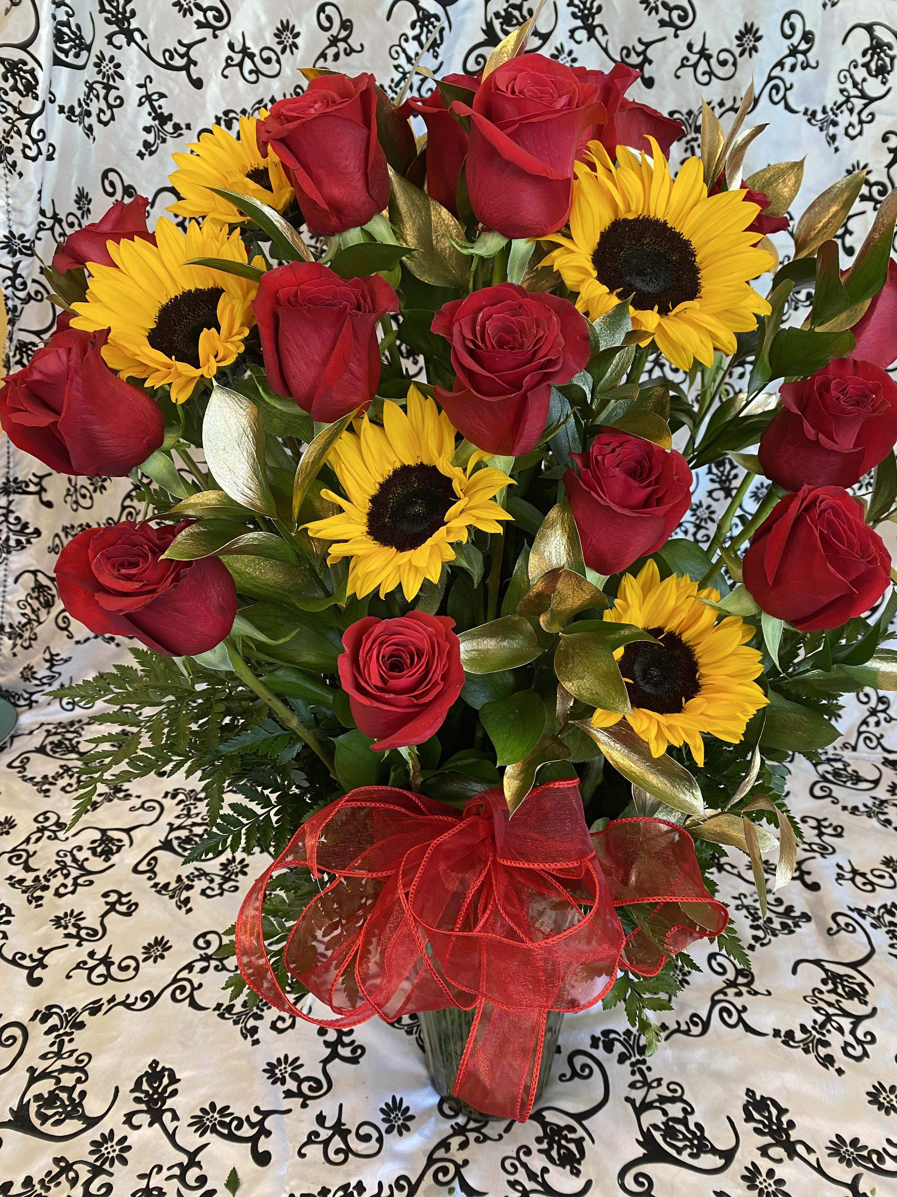 LOVE ME SUNSHINE LOVE ME SUNSHINE - WOW THIS IS A BIG ARRANGEMENT 24 RED ROSES WITH 5 SUNFLOWERS AND GOLD RUSCUS LEAVES.