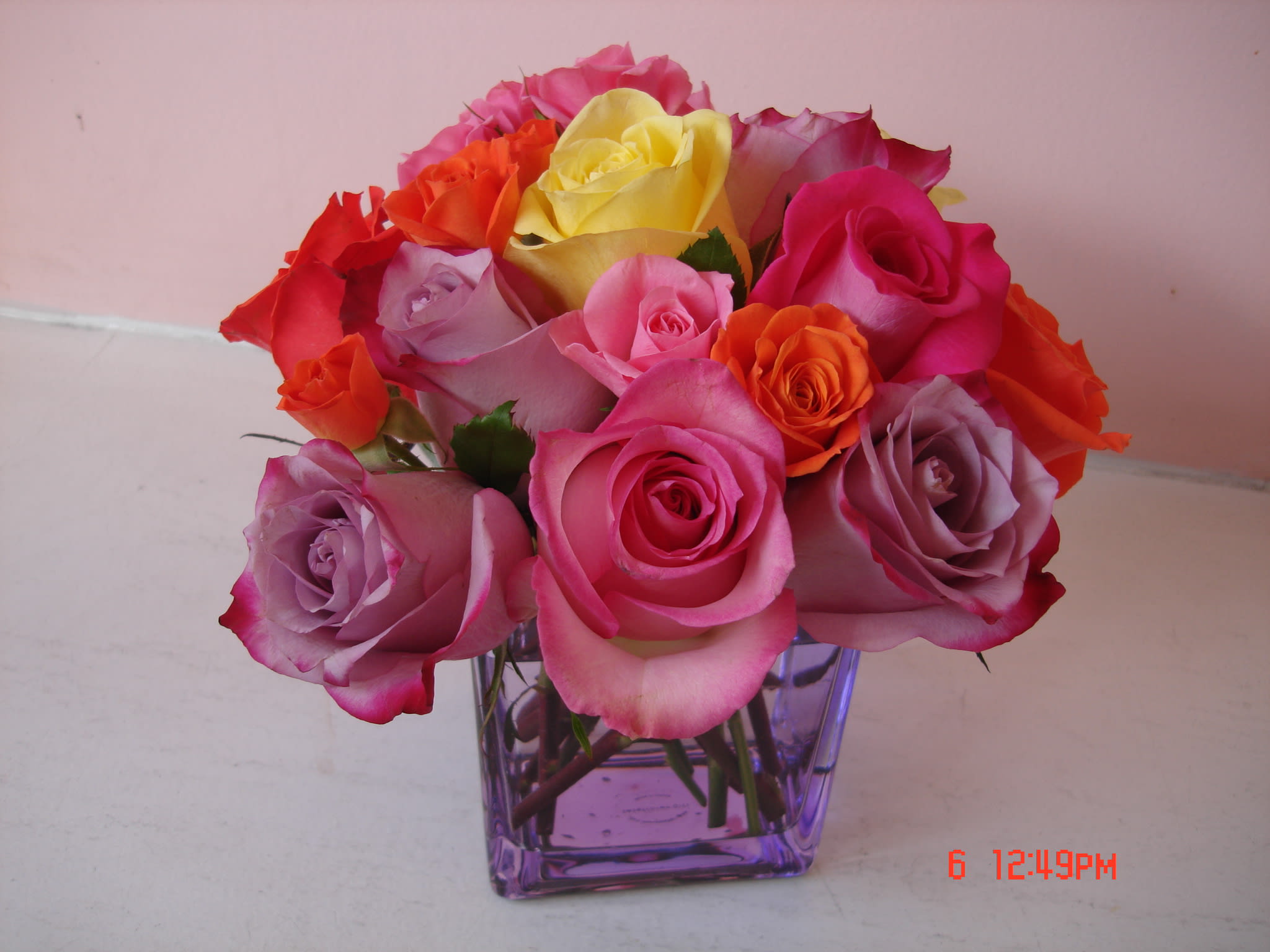 18 mixed color Roses in Lavender cube vase - W630 18 mixed color Roses in Lavender cube vase - W630 - 18 pink, lavender, yellow, roses arranged in cube glass vase. This beautiful rose arrangement is suggested for your Valentine, on Valentine's day or birthday. Will be delivered by Fillmore Flowers San Francisco's delivery crew to the address of your choice. Dimension approximately H 8"x W7" - W630