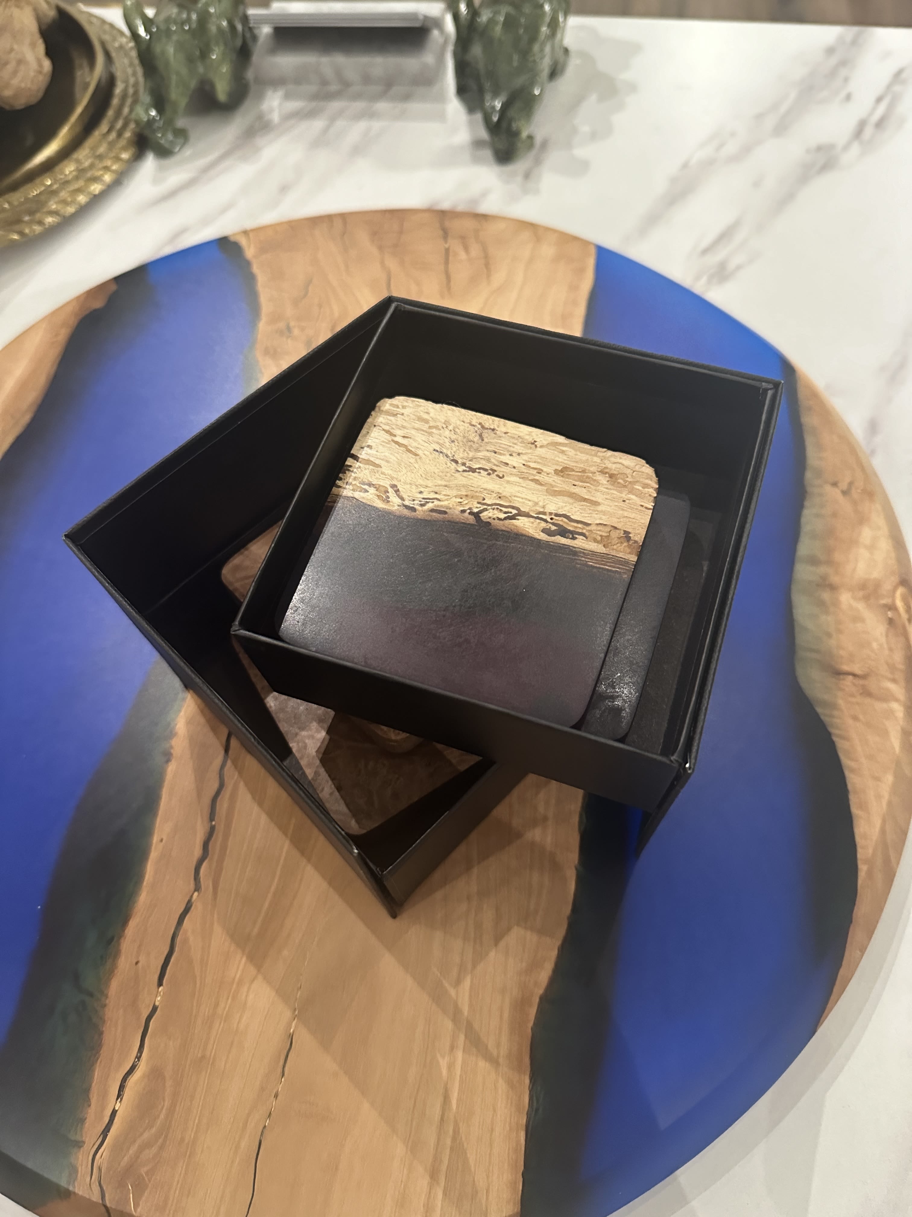 Handcrafted Burl Wood Coasters - Set of 4 (3&quot; Square) - Add a touch of natural elegance to your table with this set of 3&quot; square coasters, crafted from exquisite burl wood. Each coaster showcases the unique swirls and intricate grain patterns of the wood, making every piece one of a kind. Smooth and polished to perfection, these coasters protect surfaces while adding warmth and style to any space. Packaged in a sleek black box, they make a beautiful gift or a sophisticated addition to your home decor. Perfect for enhancing your coffee table, bar, or dining area with timeless, organic beauty.  Exclusively made for Chartreuse by Roje by Dapperwood Atelier!