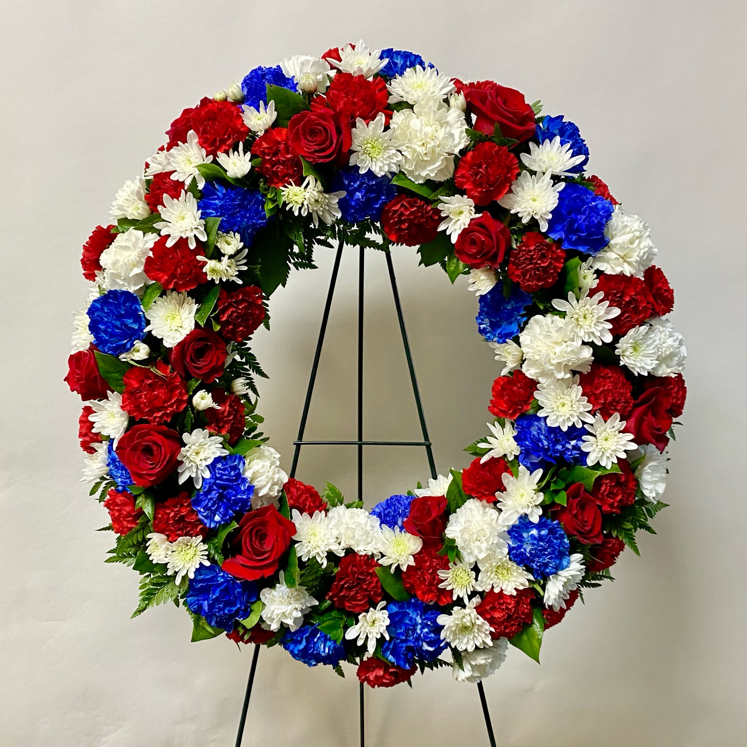 Memorial Wreath - This 18&quot; Wreath includes Red Roses, Blue Carnations, White Carnations, Red Carnations and White Cushion Mums. Or as Similar as Possible. 