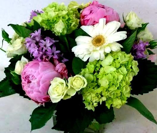 Little surprise. - This fresh arrangement with hydrangea, spray roses, daisies, roses or peonies, and stock or hyacinth, is for sure to make their day. Green, white, pink, and purple - soothing, comely colors in a cube glass vase. Surprise them a little, just because!