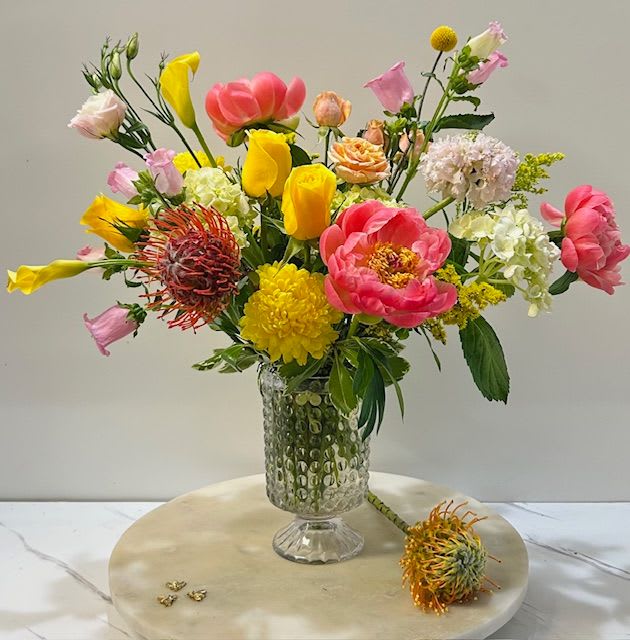 Bubble Bloom - A joyful burst of seasonal blooms—featuring lush peonies—designed in a textured glass bubble vase. This vibrant, feel-good arrangement is full of color, charm, and fresh energy to brighten any space. FLOWERS MAY VARY BASED ON AVAILABILITY.