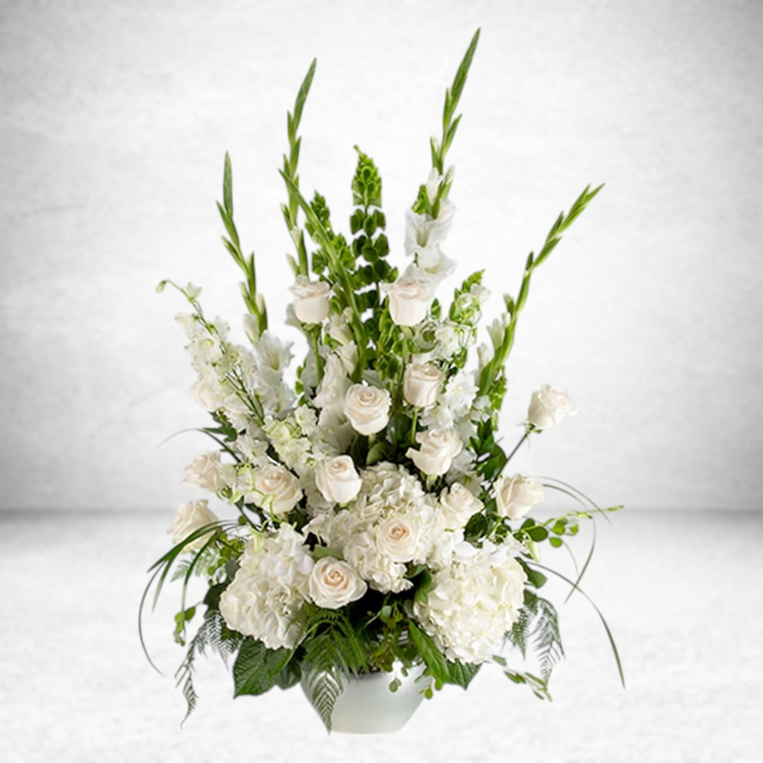 Sweet Comfort  - An all white tribute, this funeral basket is pure and tranquil. Featuring a variety of white flowers and greenery, this design reaches for the sky and evokes a feeling of peace upward and outward. 