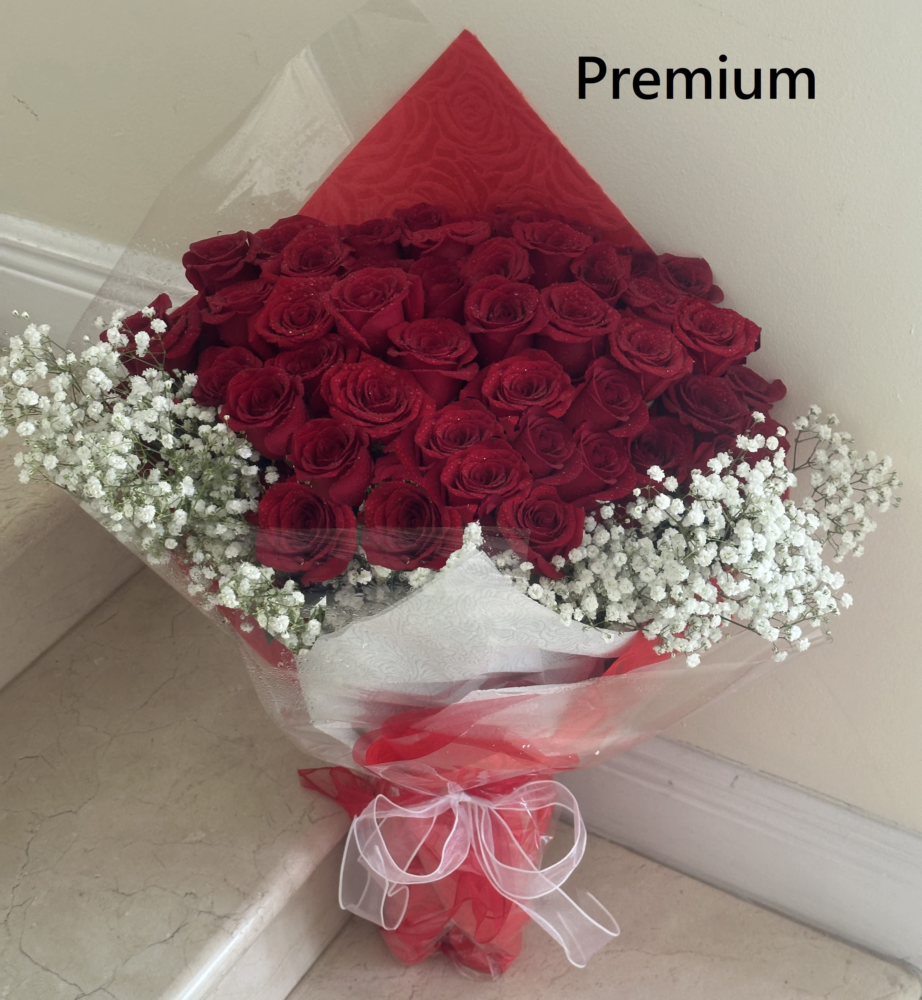 36 Red Roses long stem wrap Bouquet with Tissue and/or Cellophane paper with a Bow. - 36 Long Stem Red Roses wrapped with Tissue and/or Cellophane paper with a Bow. Beautifully arranged with a skirt of White Baby Breath and Greens.
