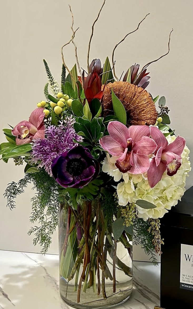 Floral Fantasy  - An abundant and colorful floral fantasy consisting of luscious Imported cymbidium orchids, sunset protea, kale and seasonal greens. This is a cheerful and sophisticated design that is an excellent choice for any season and any occasion. like thank you, new baby, congrats, just because.  Please note that specific flower varieties may vary based on availability.