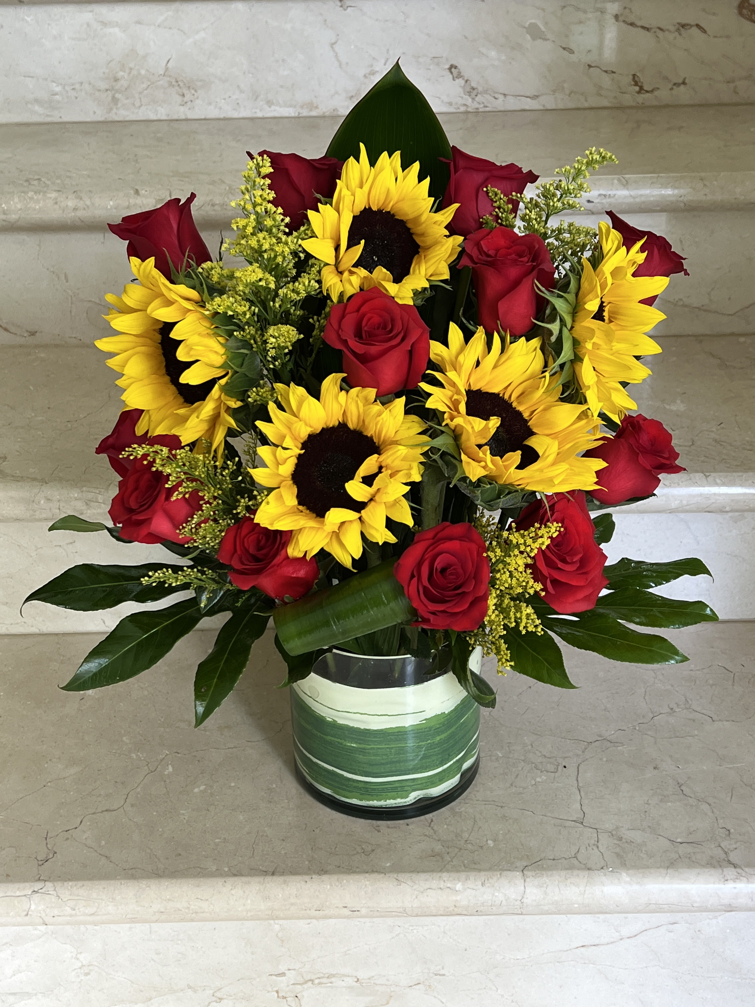 Sunflowers and Red roses arranged in a vase Sunflowers and Red roses arranged in a vase - 5 Sunflowers with 12 Red Roses and Greenery arranged in a glass vase