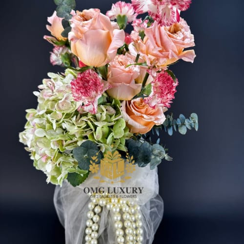 Grace &amp; Bloom&quot; Luxe Floral Wrap - Elevate any moment with our Grace &amp; Bloom Luxe Floral Wrap, a handcrafted bouquet featuring soft peach roses, hydrangeas, variegated carnations, and eucalyptus accents, beautifully wrapped in sheer tulle and finished with a string of luxury pearls.  This elegant arrangement is perfect for celebrating birthdays, anniversaries, bridal showers, or simply saying “you matter.” Whether you're gifting it in Miami or Broward County, OMG Luxury delivers beauty with a personal touch.  Crafted by OMG Luxury Gift Baskets &amp; Flowers, your go-to for luxury floral arrangements in South Florida.  Keywords: elegant flower bouquet Miami, luxury floral wrap delivery, bridal bouquet Miami, pastel bouquet with roses, high-end flower arrangements, OMG Luxury flowers.