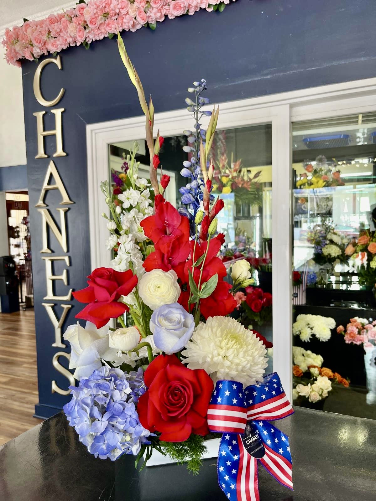 Chaney‘s God bless America! 1002 - Chaney‘s floral interpretation of celebrating and honoring the United States of America. A firework of unique floral design in Blue, Red and White!