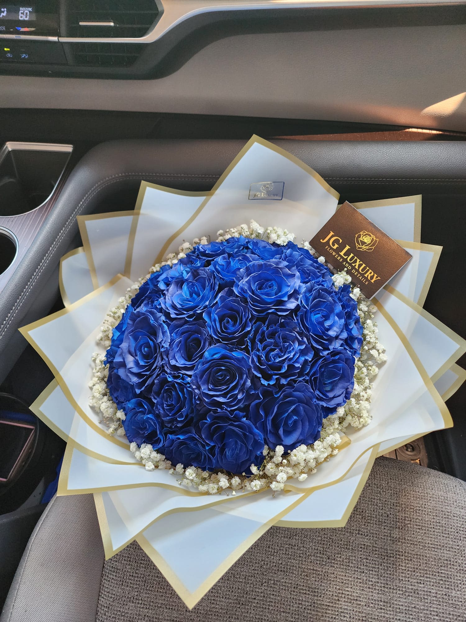 Celestia - &quot;An exquisite bouquet of vibrant blue roses, wrapped in crisp white paper surrounded by baby's breath; a striking blend of purity, and opulence.&quot; 