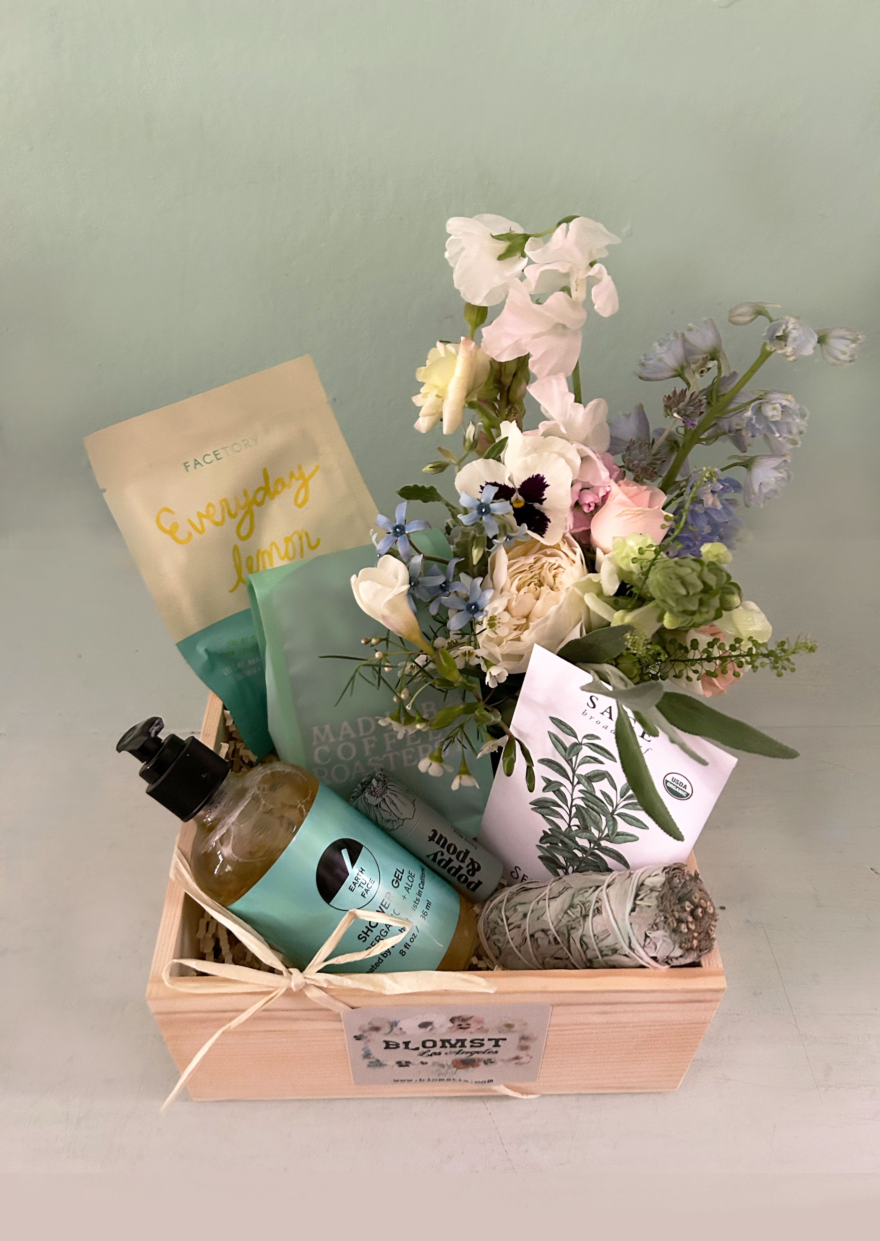 Peace in the valley box - Gorgeous box full of wellness products in mint green and sage colors. This natural and pretty box is packed with: LA made Mad Lab &quot;Dolly&quot; coffee sage seeds for the garden Smudgestick of sage Everyday Lemon face mask Earth Tu Face Bergamot + Aloe natural body wash Pure organic plant oils are saponified to create a sudsy, cleansing wash. Bergamot awakens and enlivens the senses while repairing skin damage. Organic olive oil and aloe replenish and hydrate the skin without drying. Poppy and Pout Sweet Mint lip balm All Natural Ingredients: Made with beeswax, vitamin E, organic coconut oil. Free of animal products and testing, making it an ethical choice for animal lovers. The balm comes in a compostable cardboard tube that can be safely disposed of in the environment. Adorned with a mini Blomst LA bouquet in a small cylinder vase All placed in a wooden square box or wooden basket (10 by 10 by 4). To ship a Blomst box out of state visit: www.blomstlosangeles.com