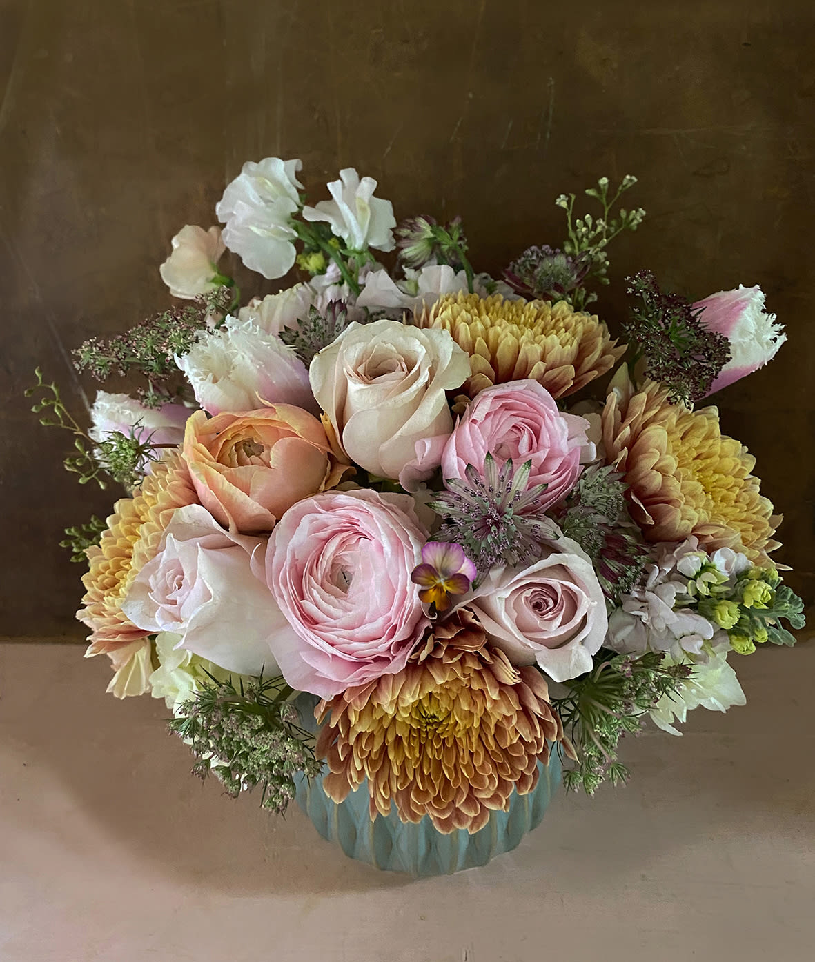 Ago dusty pastel arrangement - Make someone happy with the stylish arrangement of golden, dusty, blush colors, the perfect fashionable palette. Let a special someone enjoy the pretty crysanthemums, ranunculus and astilbe/Queen Anne's lace placed in a beautiful green container (approx. 4 by 5 inches). Blomst LA only uses fresh, high quality flowers, all carefully selected every day to fit your flower order. We offer a personal hand delivery by our own delivery staff and guarantee the flowers will look perfect, when they arrive. We deliver in Glendale, Pasadena, Eagle Rock, Hollywood, Burbank, Beverly Hills and the Pacific Palisades - and everywhere else in Greater Los Angeles.