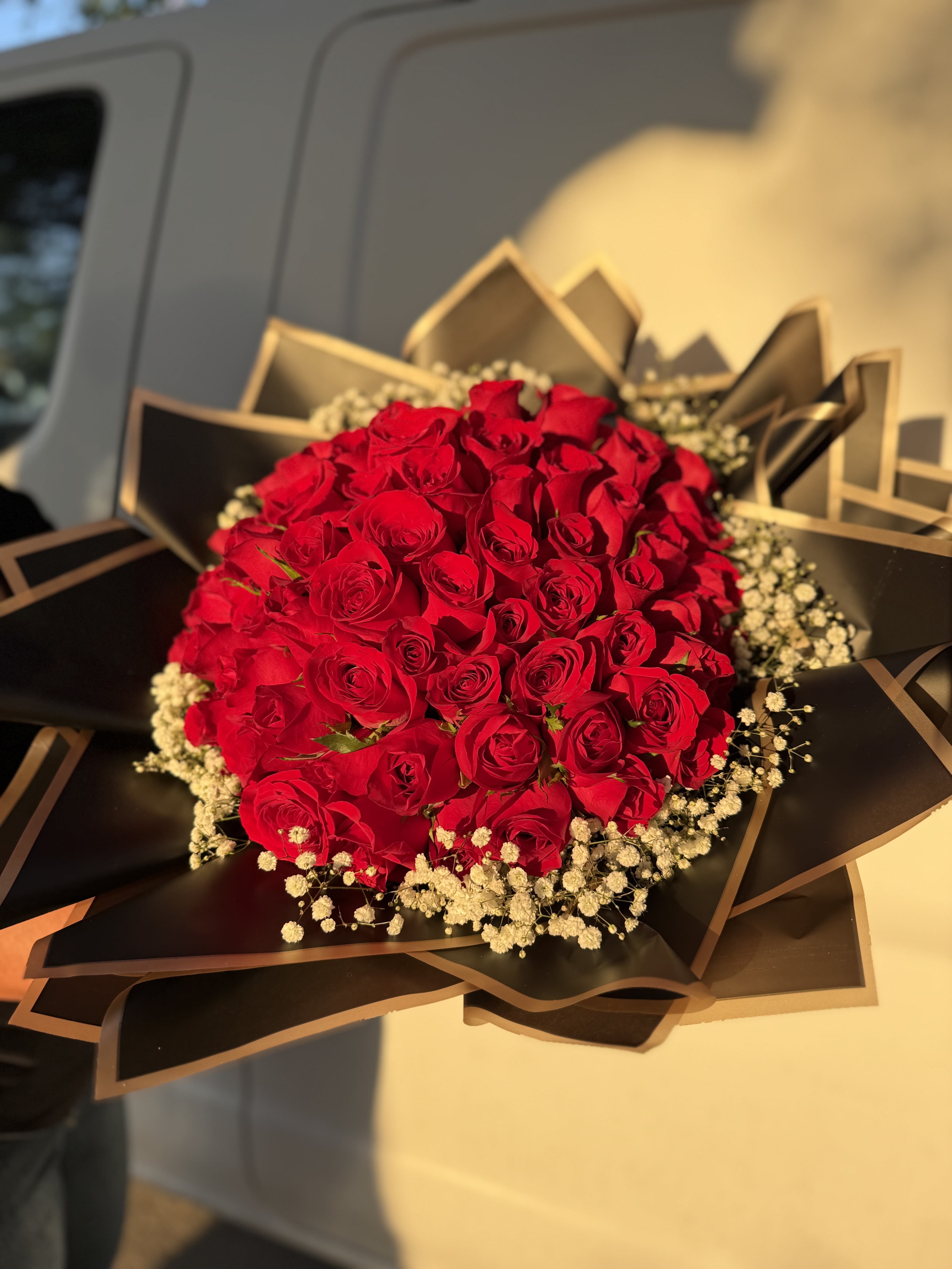 Hand-Wrapped Rose Bouquets - Fresh. Elegant. Unforgettable.  Make a lasting impression with our luxury hand-wrapped rose bouquets, featuring fresh-cut roses (19–23 inches) presented in your choice of premium floral wrapping paper.  Perfect for romantic gestures, celebrations, or “just because,” each bouquet is designed with signature Bouquet Butler elegance — minimal, modern, and meaningful.  Sizes &amp; Pricing 	•	12 Roses – $65 	•	24 Roses – $125 	•	36 Roses – $185 	•	50 Roses – $250 	•	75 Roses – $385 (featured in product photo)  	•	100 Roses – $500  Details 	•	Wrapped in your choice of elegant floral wrapping paper 	•	Optional accent florals (such as baby’s breath) included 	•	Available for pickup or delivery 	•	Custom ribbon or message tag add-ons available upon request  A bouquet without the vase — bold, timeless, and ready to impress. 