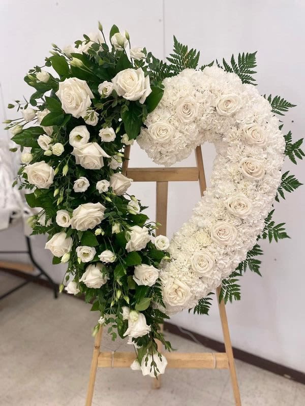 Eternal Elegance Wreath Eternal Elegance Wreath - Pay tribute to your loved one with our stunning 'Eternal Elegance Wreath.' This beautiful arrangement feature a mix white roses and other flowers, carefully crafted to create a lasting impression. The wreath is displayed on a sturdy easel, making it easy to showcase at any memorial service or funeral. Its classic design and soothing color palette evoke a sense of peace and serenity, providing comfort to those grieving. Perfect for honoring the memory of a dear friend or family member, this wreath is a thoughtful and meaningful way to celebrate their life.