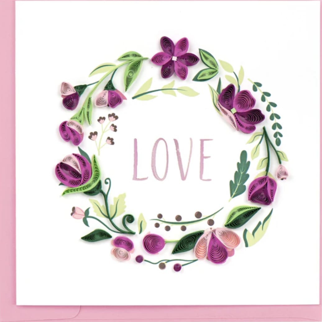 Love Floral Wreath Greeting Card - Show your eternal love with our exquisite Quilled Wreath Love card. This stunning design beautifully captures the symbol of eternity, featuring a meticulously crafted quilled wreath adorned with flowers and petals, with the word &quot;Love&quot; elegantly written in pink. The perfect card to express your everlasting love to your significant other. Outside Copy: Blank Inside Copy: Blank Size: 6 in. x 6 in. Envelope Color: Light Purple