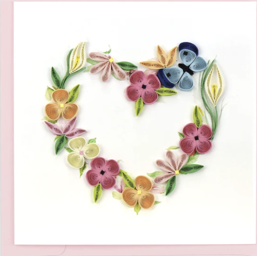 Floral Heart Wreath Floral Heart Wreath - Send a Quilled Floral Heart Wreath to someone who makes your heart bloom! This blank card is perfect for any occasion to send to someone you love year-round! The paper art shows the outline of a heart made of colorful spring flowers with a blue butterfly perched at the top left. The flowers include colors of pink, yellow, orange, green, and cream. Each quilled card is beautifully handmade by a highly skilled artisan and takes one hour to create. A quilled card is meant for you to share, treasure as a keepsake, or display as the work of art it is.