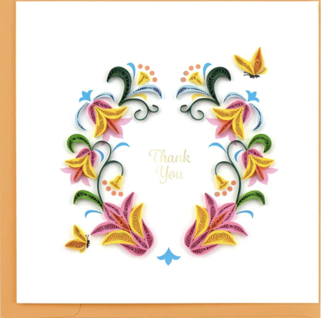 Thank You Flower Wreath Card Thank You Flower Wreath Card - This vibrant, floral design makes for a perfect thank you card. Quilled paper strips in pink and yellow hues are arranged to create decorative flowers in the shape of a wreath, along with green leaf accents. 'Thank You' is printed in the center of the design and a couple of butterflies surround the flowers. Show your gratitude with a beautiful piece of handcrafted art. Don’t just send a card, send art! Verified Fair Trade Federation Member Outside Copy: Thank You Inside Copy: Blank plus additional blank insert to write your own message on Size: 6 in. x 6 in. Envelope Color: Orange