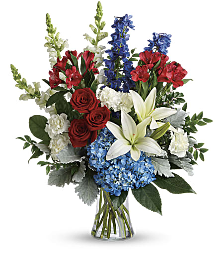 Colorful Tribute Bouquet - Perfectly patriotic with its red, white and blue blooms, this bold bouquet of hydrangea, lilies and roses is a versatile tribute on any occasion.  This bouquet features blue hydrangea, red roses, white asiatic lilies, red alstroemeria, white carnations, blue delphinium, white snapdragons, huckleberry, dusty miller, aralia leaf and lemon leaf. Delivered in a gathering vase. Approximately 22&quot; W x 26&quot; H