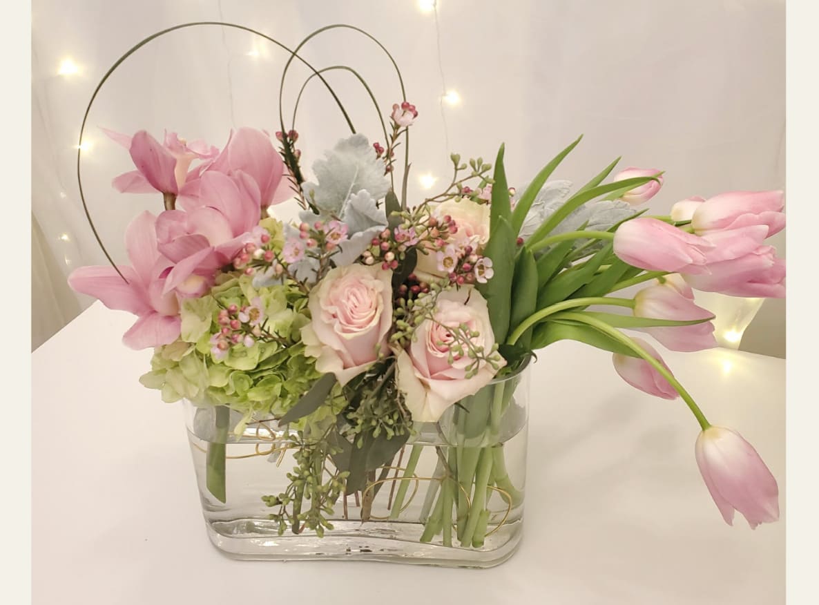Simply Pink - One of our client favorites,  This  beautiful arrangement consists of cymbidium orchids, hydrangea, roses and tulips