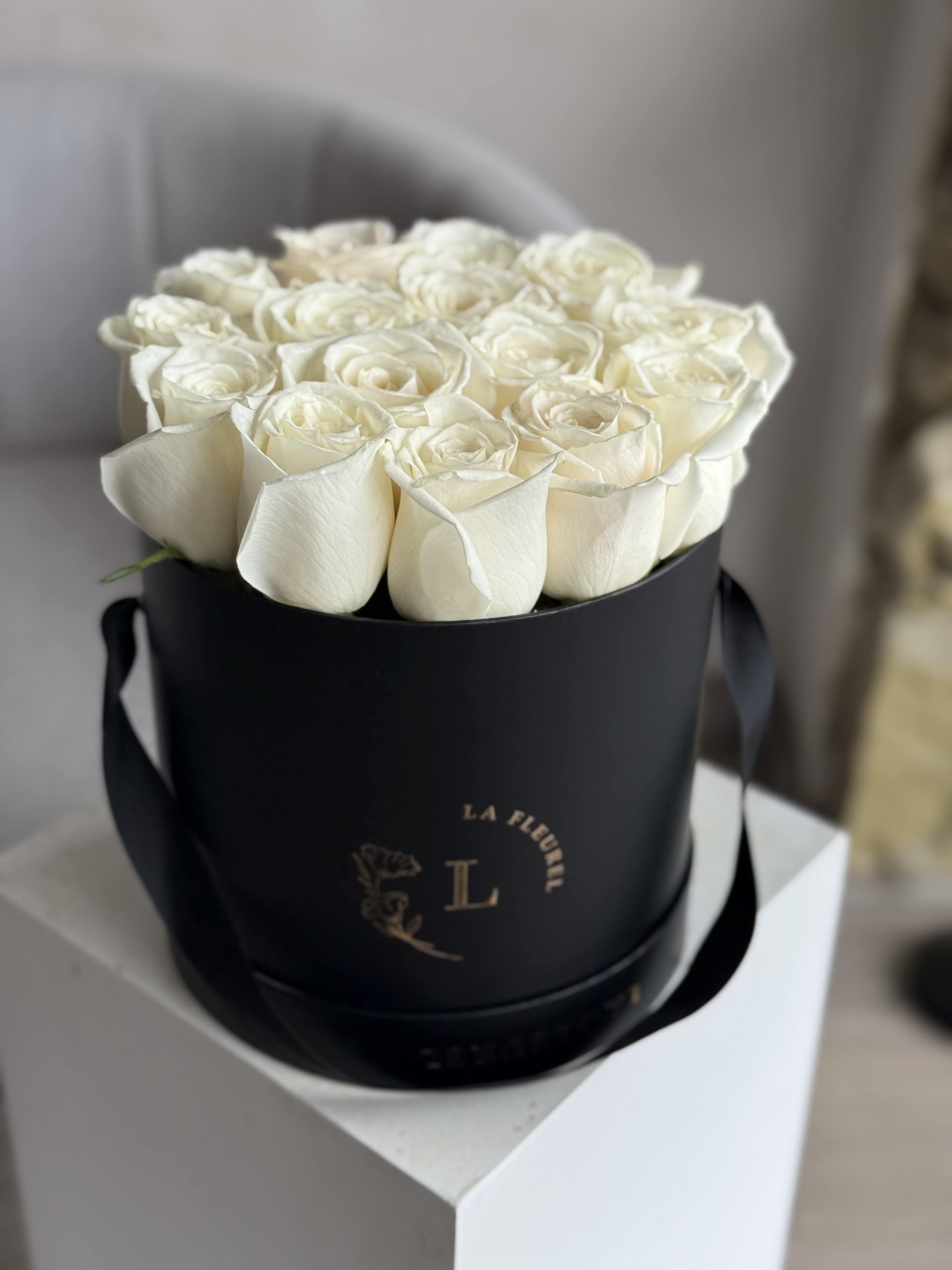 White Playa Elegance - A refined symphony of purity and grace—this arrangement features 15 luxurious White Playa Blanca roses, known for their full, velvety blooms, paired with a delicate orchid for an added touch of sophistication. Presented in a sleek black box, this design is a bold yet timeless expression of elegance, perfect for life’s most meaningful moments.