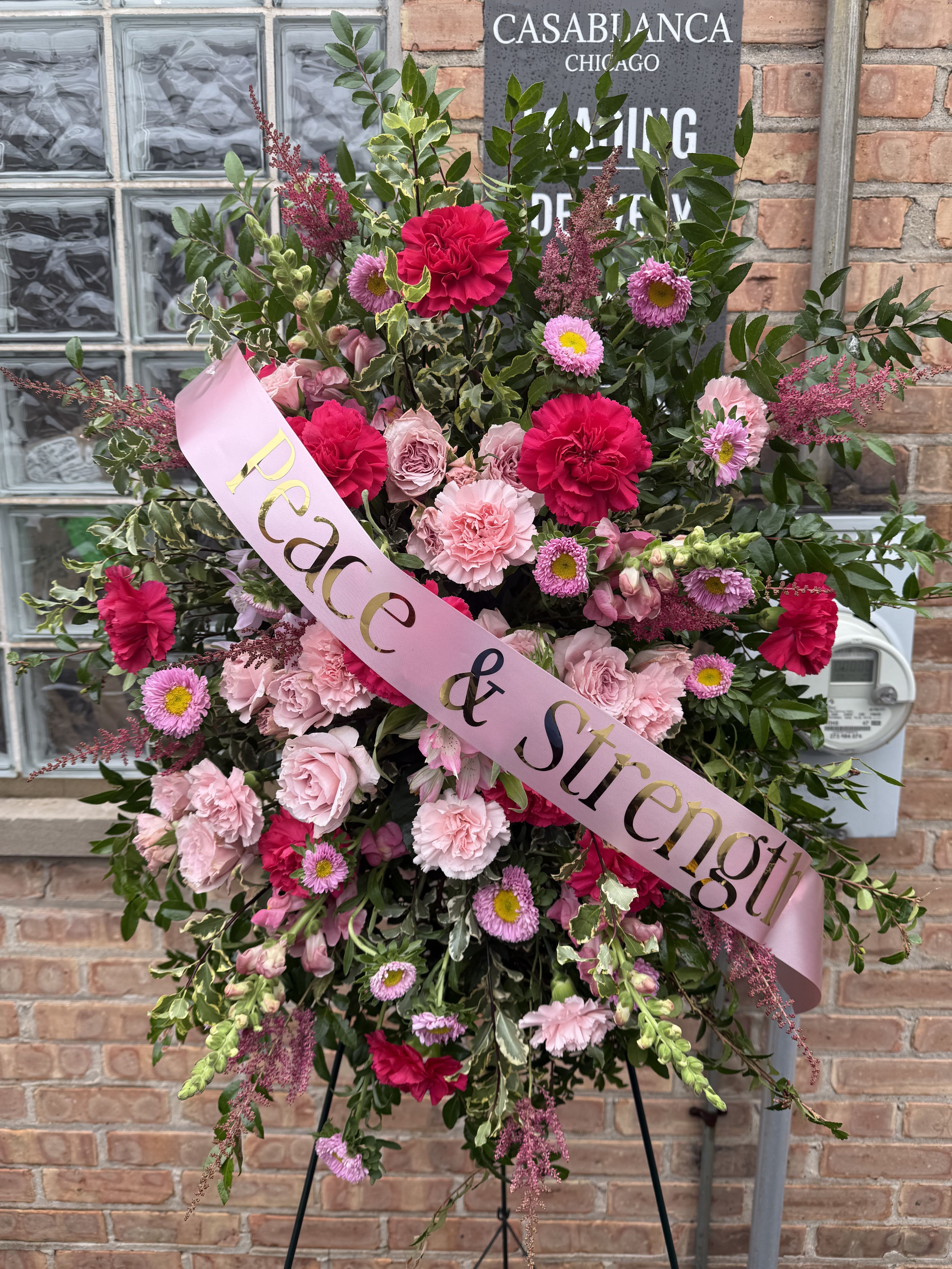 Peace & Strength Pink Matsumoto Spray Peace & Strength Pink Matsumoto Spray - Pink Astilbe, pink Matsumoto, pink carnations and hot pink carnations, pink alstromeria and pink roses in a beautiful arrangement. You may customize the ribbon.