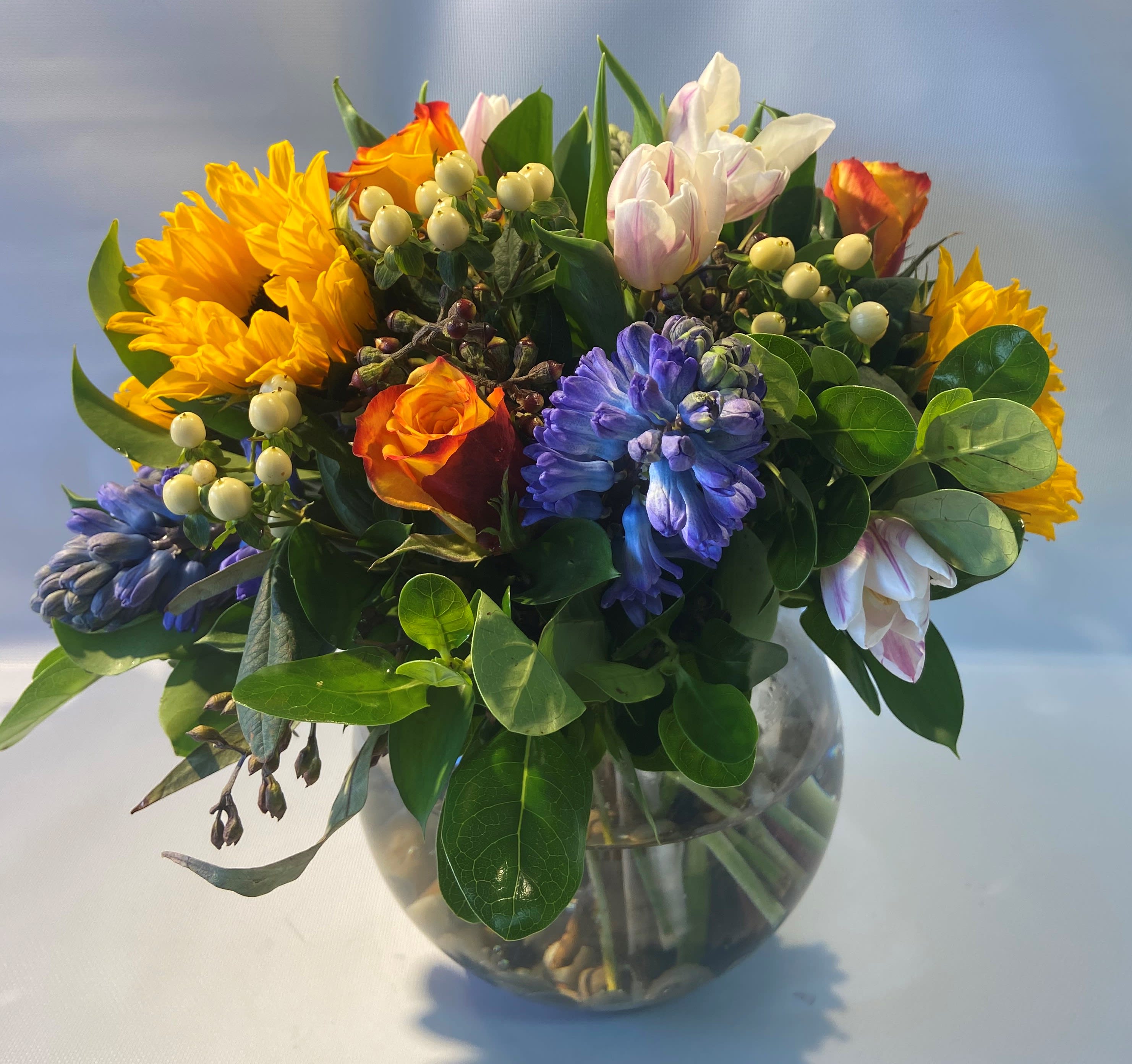 Rainy Sunshine Rainy Sunshine - Like rainy sunshine, the colors are a beautiful mix of blue and yellow with pastels mixed in. Hyacinth, tulips, and sunflowers are the highlight of this mixed bouquet.