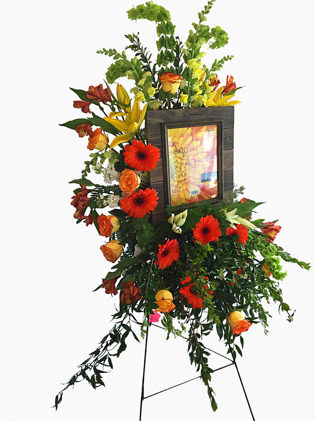 Remembrance - Sympathy spray featuring an 8&quot; x 10&quot; framed picture of your loved one. This gentle arrangement features gerbera daisies, lilies, alstroemeria, roses, bells of ireland, and assorted greens.   Colors and flowers may be substituted. Picture frame varies depending on availability, or you may bring your own frame. 