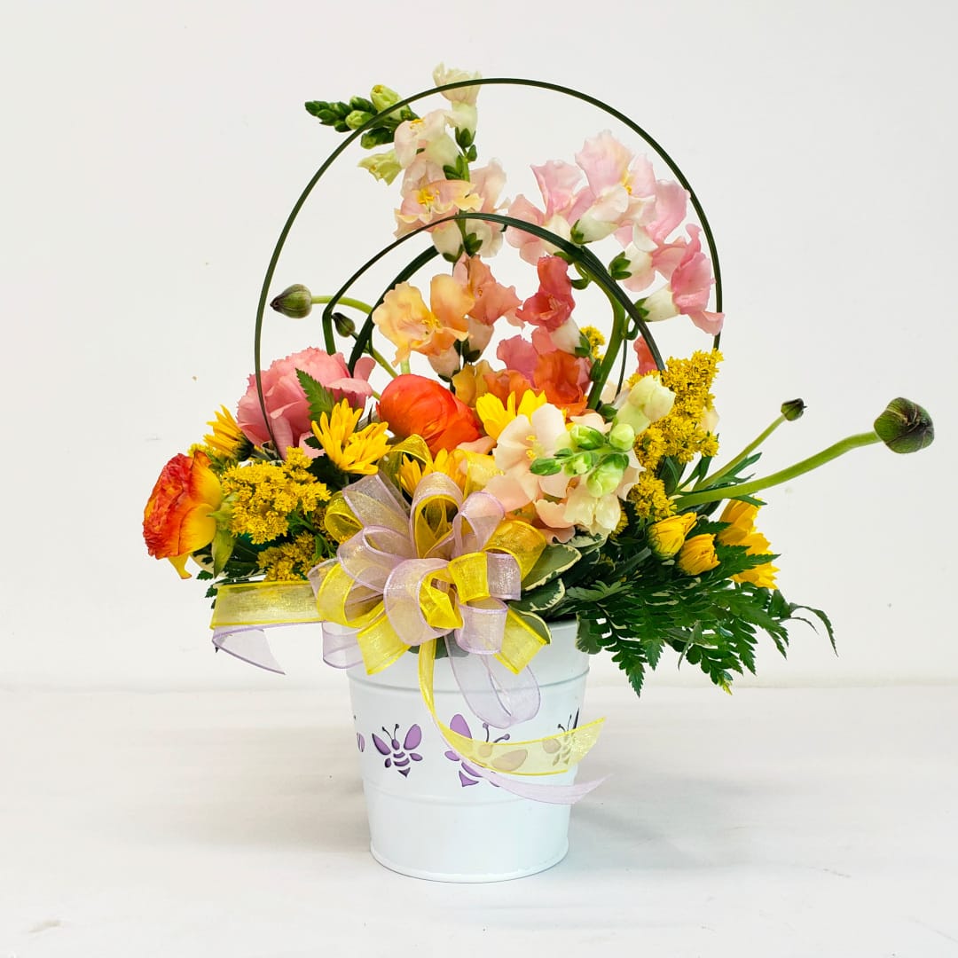 Beeautiful - Spring floral celebration with arrching lily grass, set in an adorable bee cutout metal container. Makes a lovely Mother's Day gift! Upgrade to deluxe for additional Designer's Choice enhancements to the arrangement. Bee colors vary. Approximate dimensions: 10&quot;W x 12&quot;H.