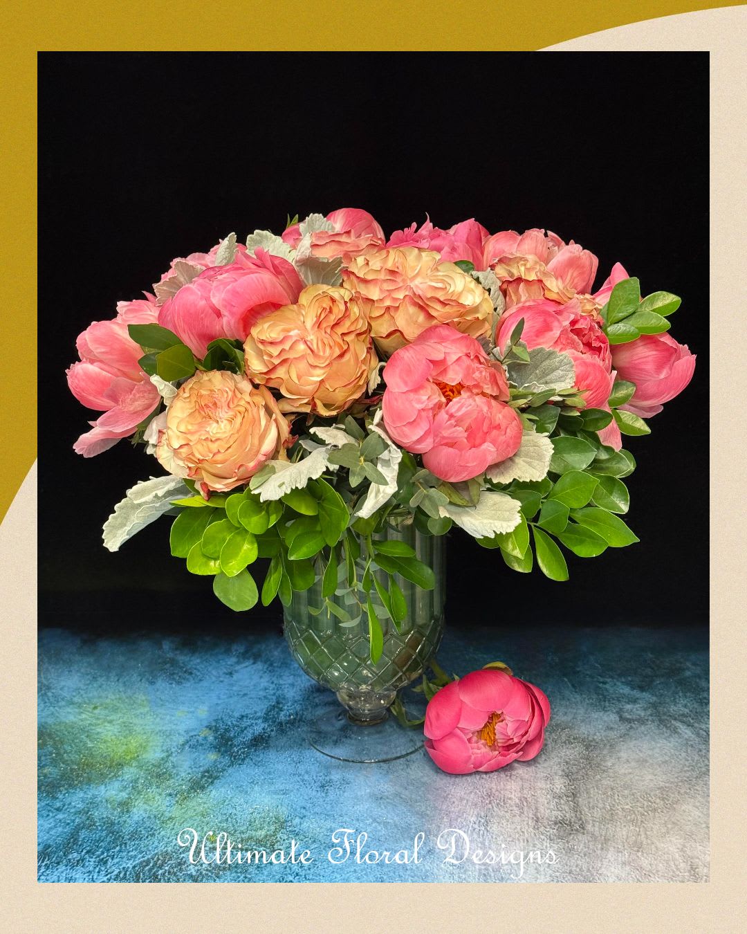 Sun-Kissed Charm Sun-Kissed Charm - A radiant mix of coral peonies and peach garden roses, accented with soft dusty miller and vibrant greenery. Arranged in an elegant glass vase, this design by Flora at Ultimate Floral Designs brings charm, color, and luxury to any space.