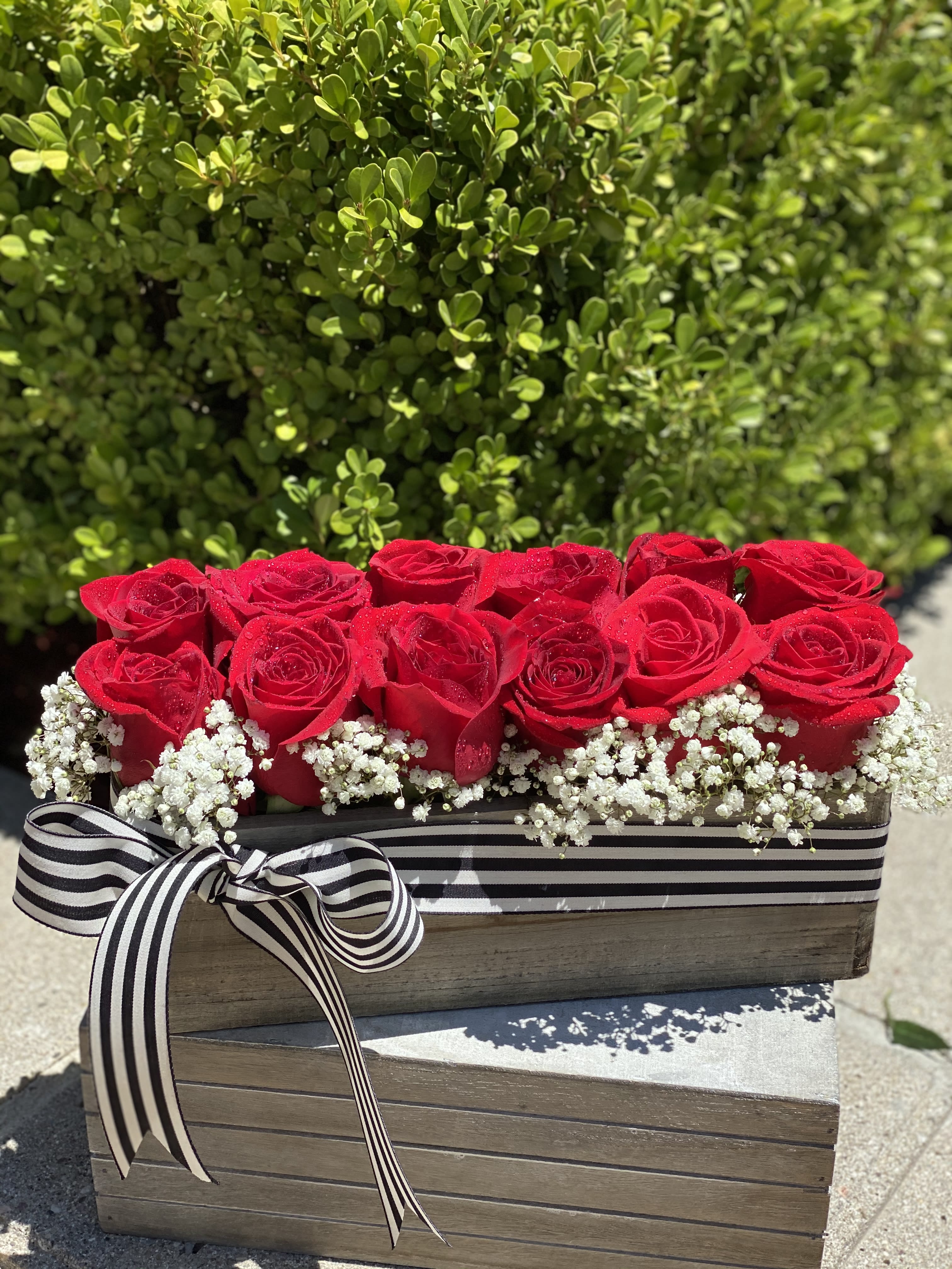 Classy Grad Classy Grad - say Congratulation to your Graduate with A dozen red roses are arranged in a wooden box accented with baby's breath. This design gives the classic dozen roses a trendy and modern twist.