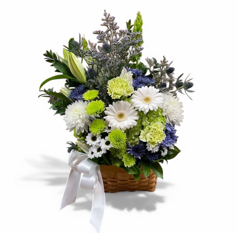 Lush Tranquility Basket Lush Tranquility Basket - This flower basket features a lovely yet soft arrangement of flowers in shades of white, green, and blue. The bouquet includes lilies, carnations, daisies, and various greenery, all presented in a light brown wicker basket. A white ribbon box is included and placed neatly to complement the basket, adding a touch of elegance to this beautiful basket arrangement.