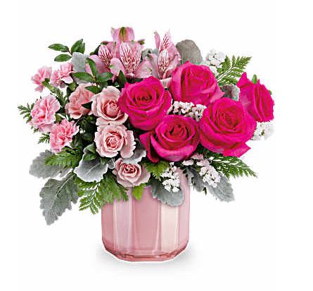 BLUSHING GEM - Keep them blushing with the most beautiful pink Valentine's Day bouquet, elegantly displayed in a sculpted pink glass vase featuring a stunning pearlescent finish. This Valentine's Day arrangement showcases hot pink roses, pink spray roses, pink alstroemeria, miniature pink carnations, white sinuata statice, dusty miller, huckleberry, and leatherleaf fern. This beautifully pink bouquet is delivered in Teleflora's Blushing Gem Vase. Orientation: All-Around 