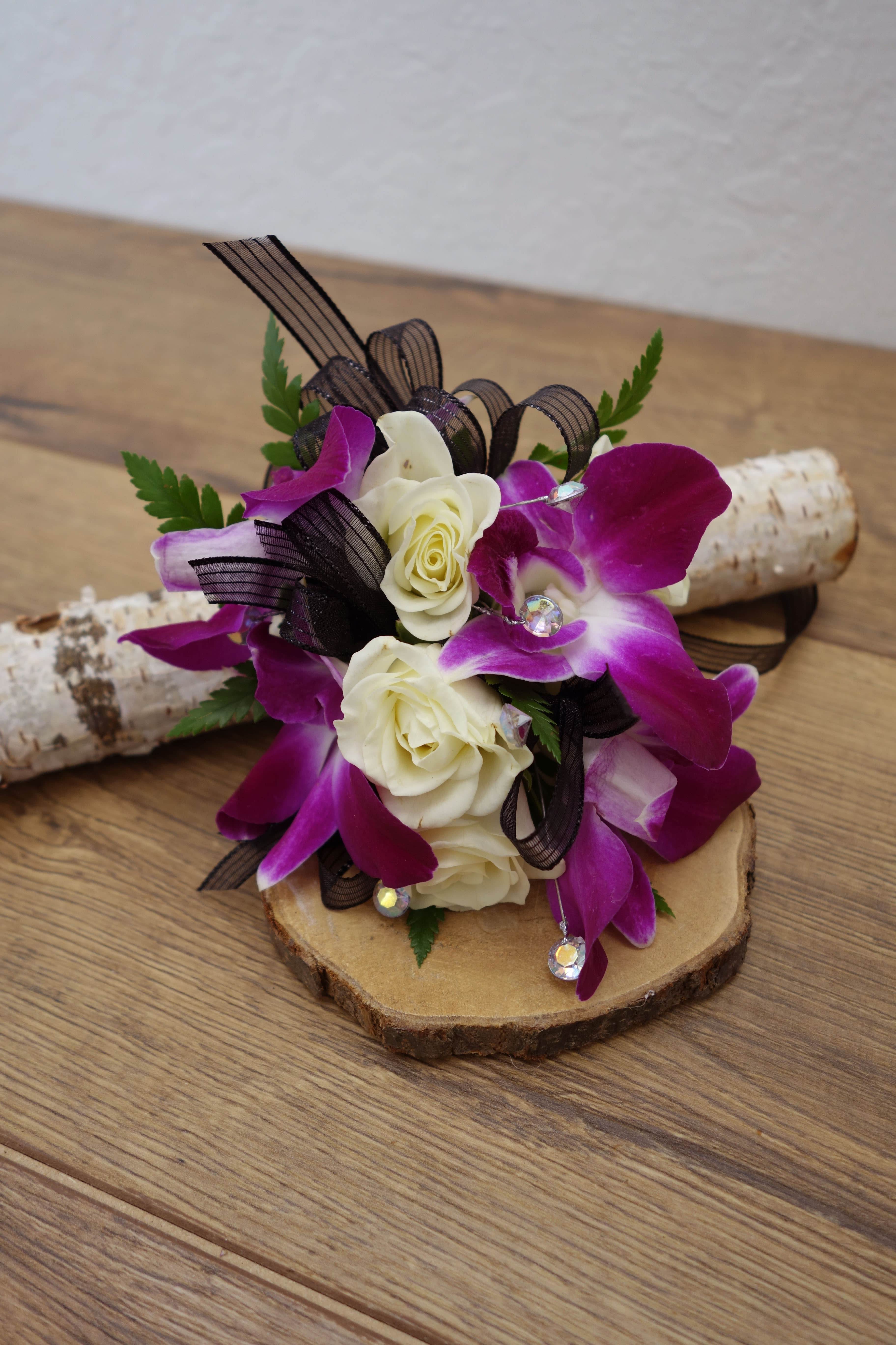 C#08 Purple Dendro. Orchid &amp; White Spray Rose Corsage (Pre-Order Item) - This dendrobium orchid with white spray roses corsage and gem accent will catch the light and compliment any dress. Perfect for prom, formal or any wedding event.   **According to your needs ribbon color can be replaced to others.  **This is a special order, please order 3-5 days in advance (no next day or same day pick up order). Please call our store if needed within 3 days.