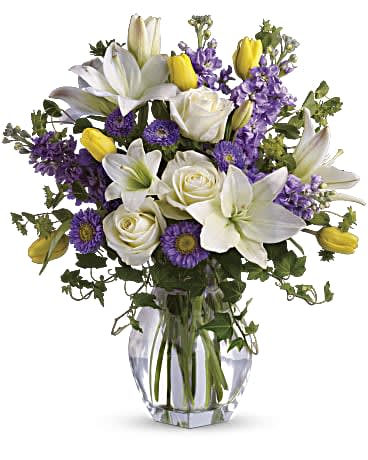 Spring Waltz Spring Waltz - Dance into spring! Send this feminine bouquet of favorite spring flowers to brighten someone's home with the playful beauty of nature. Such a pretty way to say, "I'm thinking of you!" This white, lavender and yellow bouquet includes white asiatic lilies, cream roses, yellow tulips, lavender stock, lavender matsumoto asters and greens including bupleurum, ivy and seeded eucalyptus. Delivered in a gorgeous reception vase. Orientation: All-Around