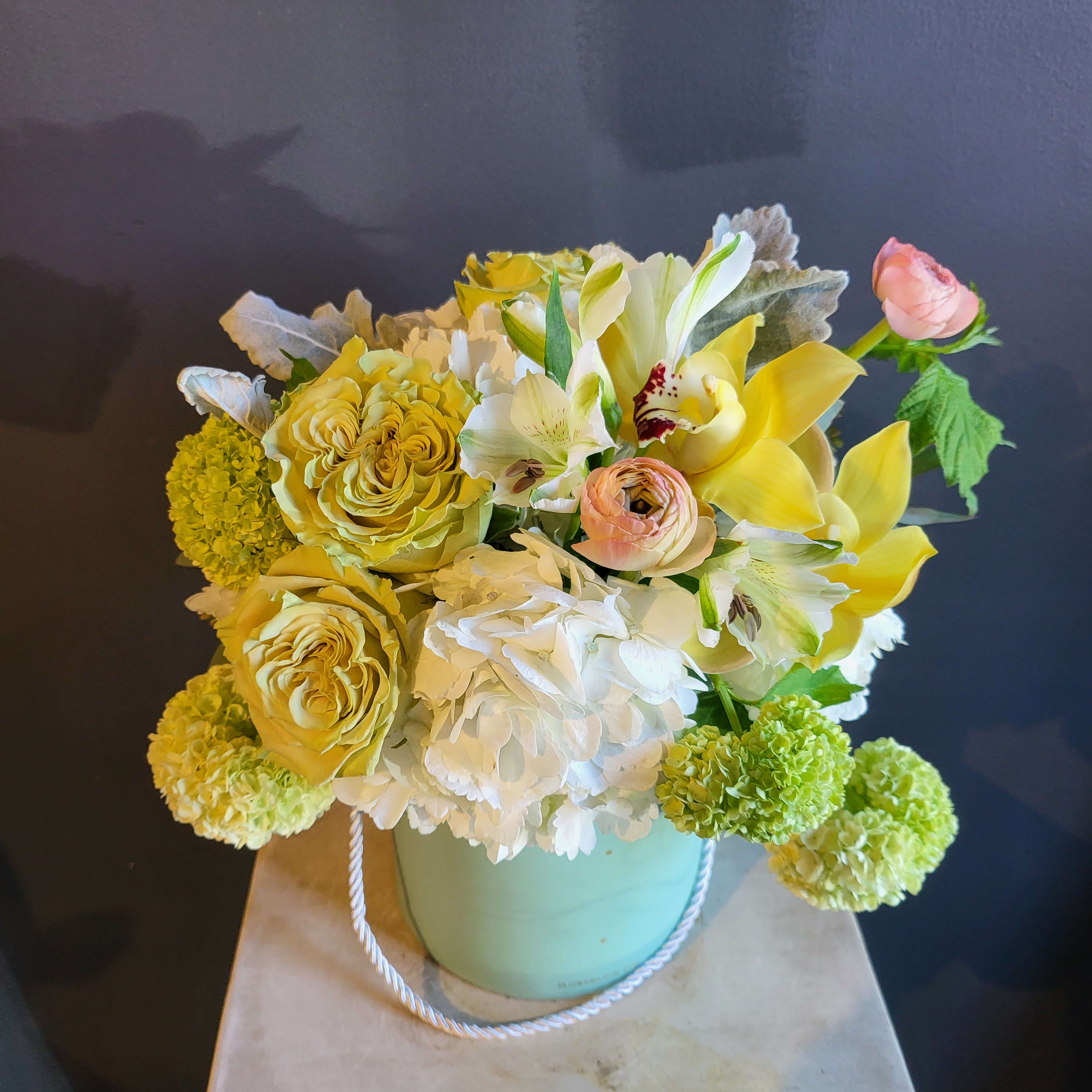 SG-56 - Medium sized arrangement.  **** Please Read **** - This arrangement has front and back, which means we focus and put more flowers in the front and the backside will have a cover of a hatbox. If you are looking for all around arrangement, please chose deluxe and leave a note for florists.  - The box is made with water proof cardboard but it still needs extra care when you add water.  * If you are worried about it, please leave a note for florists to substitute with other vase such as clear glass vase or ceramic vase. We will substitute without any extra charge. *Colors or shapes of Boxes are subjects to change.  Due to various seasonal and regional conditions, and the variety of unplanned issues courtesy of Mother Nature, availability of some flowers may be very limited in certain areas.  In this event, we will substitute with a second choice of similar flowers and container of equal value and beauty. Every effort will be made to maintain size, shape, and overall color schemes of an arrangement. Our goal is your complete satisfaction, rest assured that every effort will be made to provide an arrangement of equal or greater value.  
