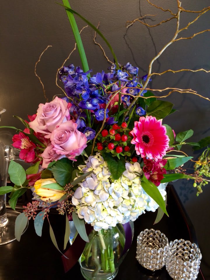 SG-3 - Tall arrangement with blue delphiniums, roses, tulips and more!  If you are looking for pastel, or any preferred color, please leave a note for Florists when you checkout.  * Due to various seasonal and regional conditions, and the variety of unplanned issues courtesy of Mother Nature, availability of some flowers may be very limited in certain areas.  In this event, we will substitute with a second choice of similar flowers and container of equal value and beauty. Every effort will be made to maintain size, shape, and overall color schemes of an arrangement. Our goal is your complete satisfaction, rest assured that every effort will be made to provide an arrangement of equal or greater value. 