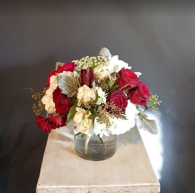 SG-9 - Medium sized arrangement with premium roses, garden roses, and other flowers    Due to various seasonal and regional conditions, and the variety of unplanned issues courtesy of Mother Nature, availability of some flowers may be very limited in certain areas.  In this event, we will substitute with a second choice of similar flowers and container of equal value and beauty. Every effort will be made to maintain size, shape, and overall color schemes of an arrangement. Our goal is your complete satisfaction, rest assured that every effort will be made to provide an arrangement of equal or greater value