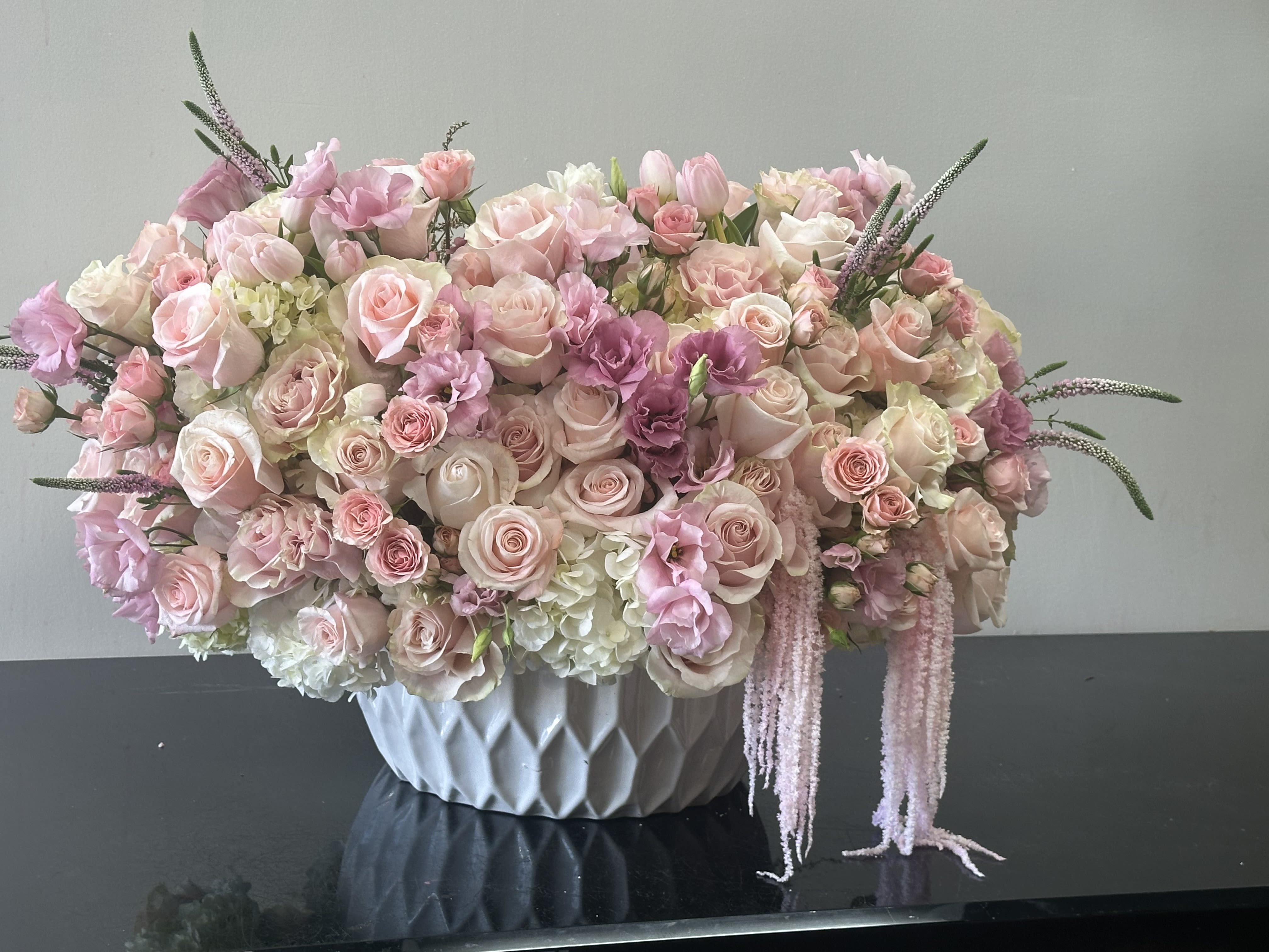 Candy Cane Candy Cane - Tender pinks with a blend of peach blooms and assortment of flowers creates a display of texture and playfulness showcased in a chic white vase a stem of dried pink Amaranthus for candy cane touch. Roses, spray roses, hydrangeas, lisianthus, tulips Some florals are seasonal, if particular flower will not be available due to season, we will substitute for similar flower, composition, color pallet and value of the arrangements as closely as possible. All effort to create a floral arrangement as close to the photo shown, the actual arrangement may vary slightly in its appearance from the photo shown. If you have any questions about your order, we welcome you to call us in or email