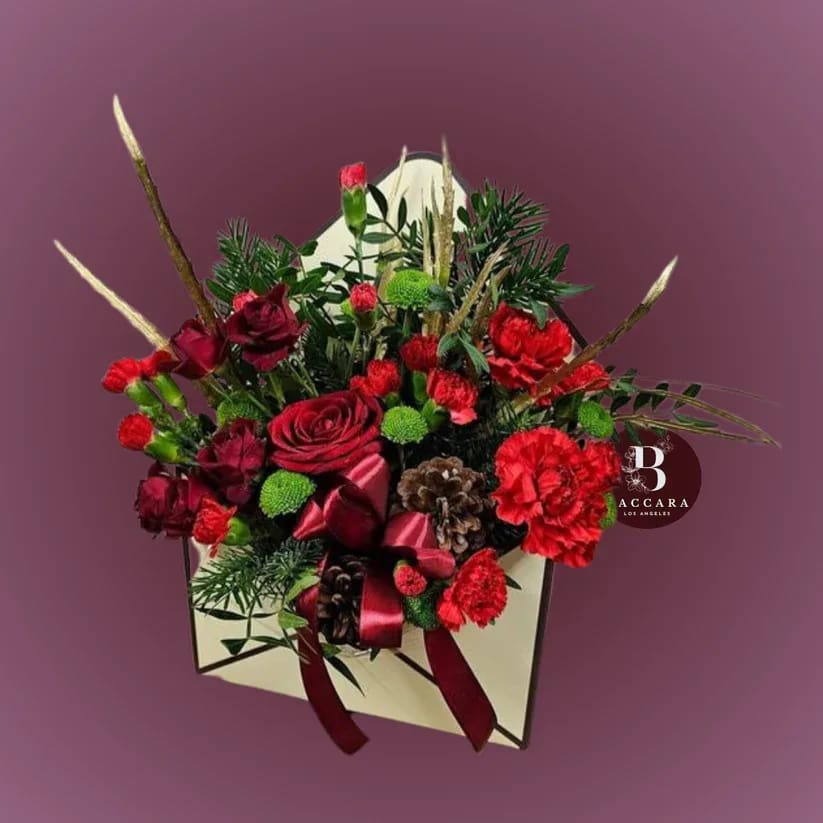 Crimson Glow: Winter Floral Arrangement Crimson Glow: Winter Floral Arrangement - Illuminate your winter with our Crimson Glow floral arrangement! This stunning display features a captivating mix of light and dark red blooms, including rich burgundy roses and soft crimson carnations, beautifully complemented by lush evergreen accents. Perfect for festive gatherings or cozy evenings at home, this arrangement adds warmth and elegance to any space. Celebrate the season's charm and create a joyful atmosphere with this striking blend of colors that embodies the spirit of winter! Disclaimer: Product images are for reference only. Actual flower shades, box colors, and arrangement styles may vary slightly based on seasonal availability and stock. We always strive to match the overall style, color palette, and quality shown in the photos, ensuring every arrangement is fresh, beautiful, and thoughtfully curated.