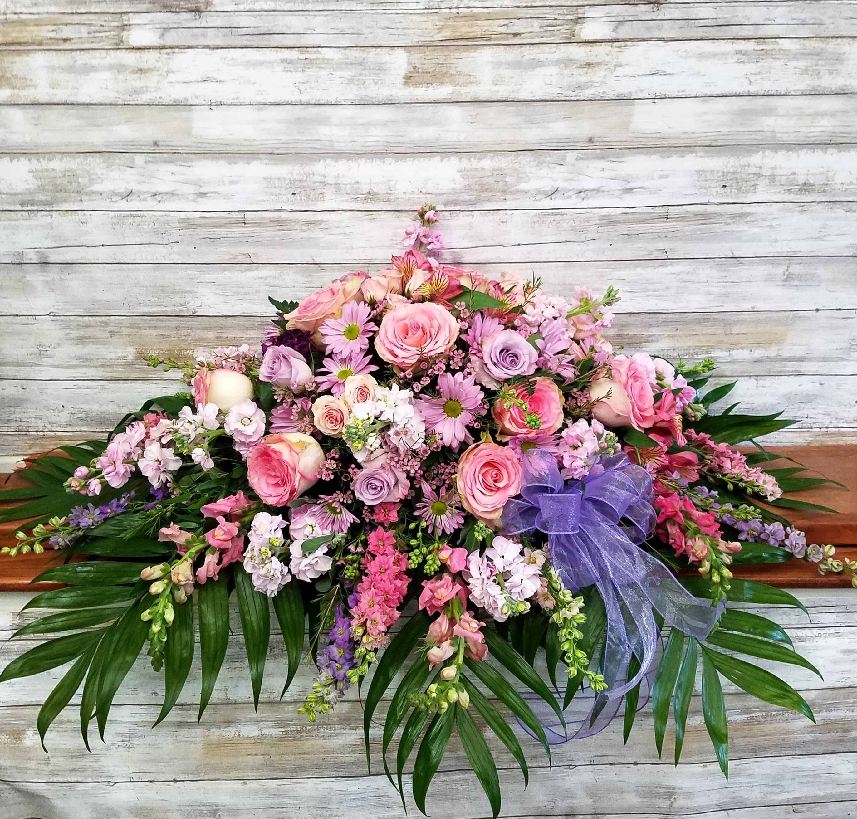 A Loved Life Casket Spray Half-Size for Open Casket - A magnificent cascade of pink and lavender floral favorites conveys an outpouring of love and respect for one who has passed.  Full Size Also Available 