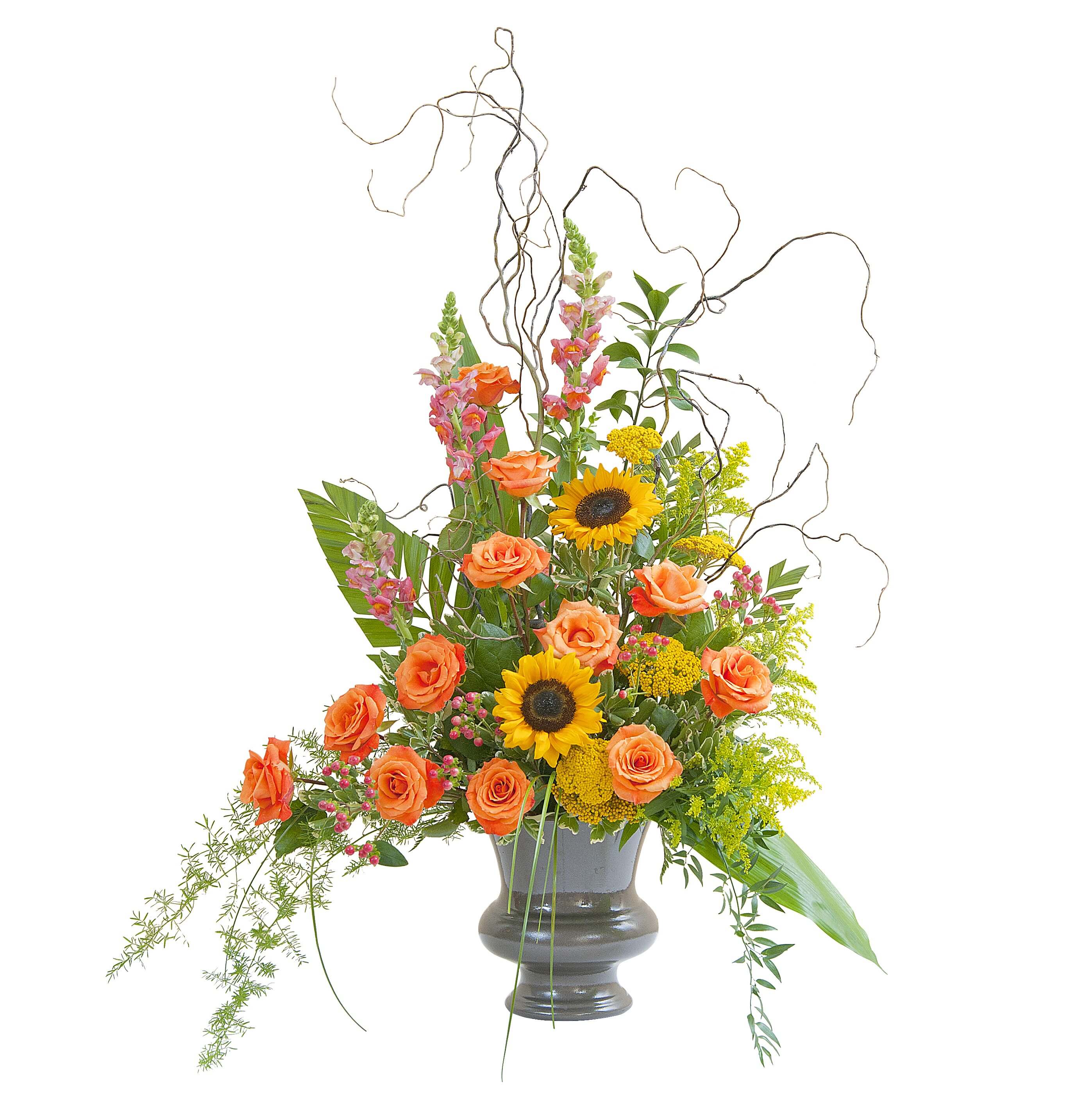 Heaven's Sunset Large Urn Heaven's Sunset Large Urn - The colors of sunset are evident in this urn filled with Sunflowers, Roses, and accents of other premium flowers and foliage.
