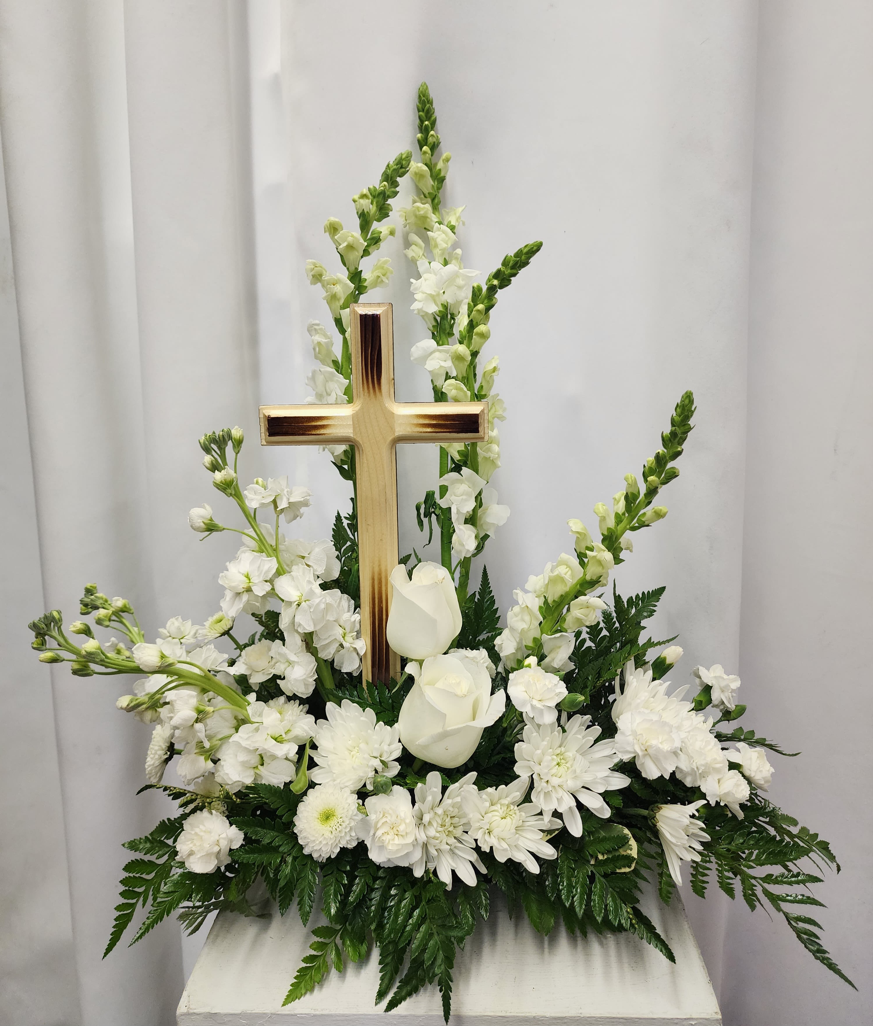 Peaceful Sentiment Peaceful Sentiment - A touch of serenity and elegance with a handcrafted 12" wooden cross keepsake. This stunning piece features a harmonious blend of all white flowers, signifying peace and calm. The expertly crafted wooden cross is sure to be treasured for years to come. At times substitutions may be necessary but the style and color of the arrangement will be maintained for the ethereal symbolism.