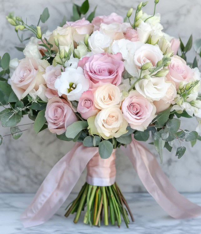 First Light Bridal Bouquet First Light Bridal Bouquet - This bridal bouquet features blush and ivory roses, lisianthus, and eucalyptus, creating a soft, romantic look