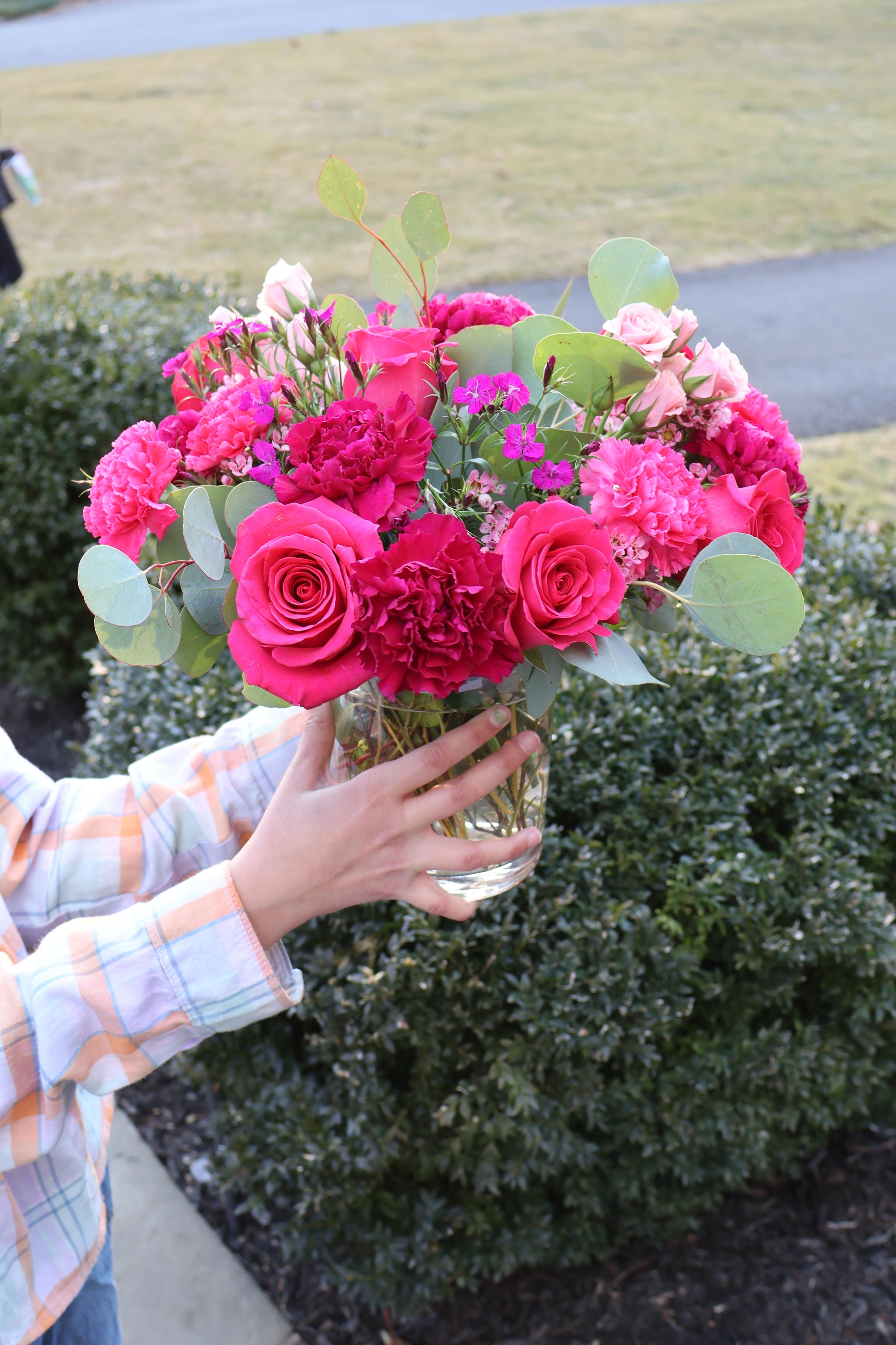 	Pink Champagne - A lush and romantic floral arrangement featuring deep magenta roses, vibrant carnations, and soft eucalyptus greens. Designed in a clear glass vase, this bouquet bursts with passion, charm, and timeless beauty—perfect for expressing love or brightening any space